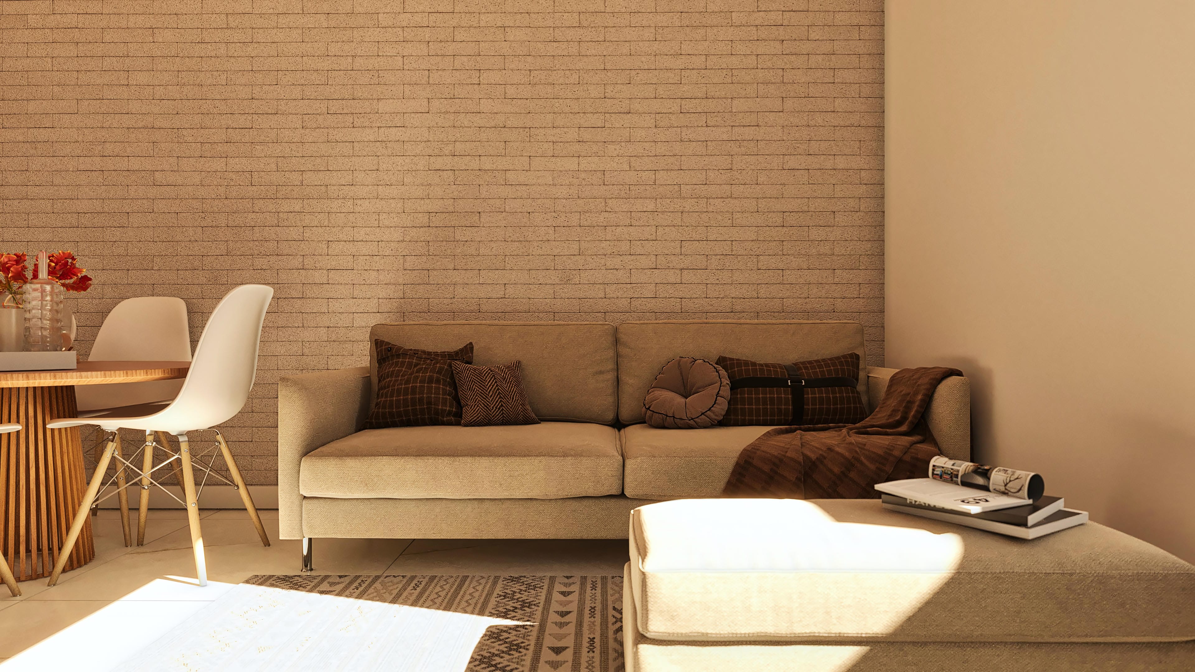Detalle de sala de estar con pared de ladrillos claros, sofá beige con cojines decorativos y mesa de comedor con sillas blancas.