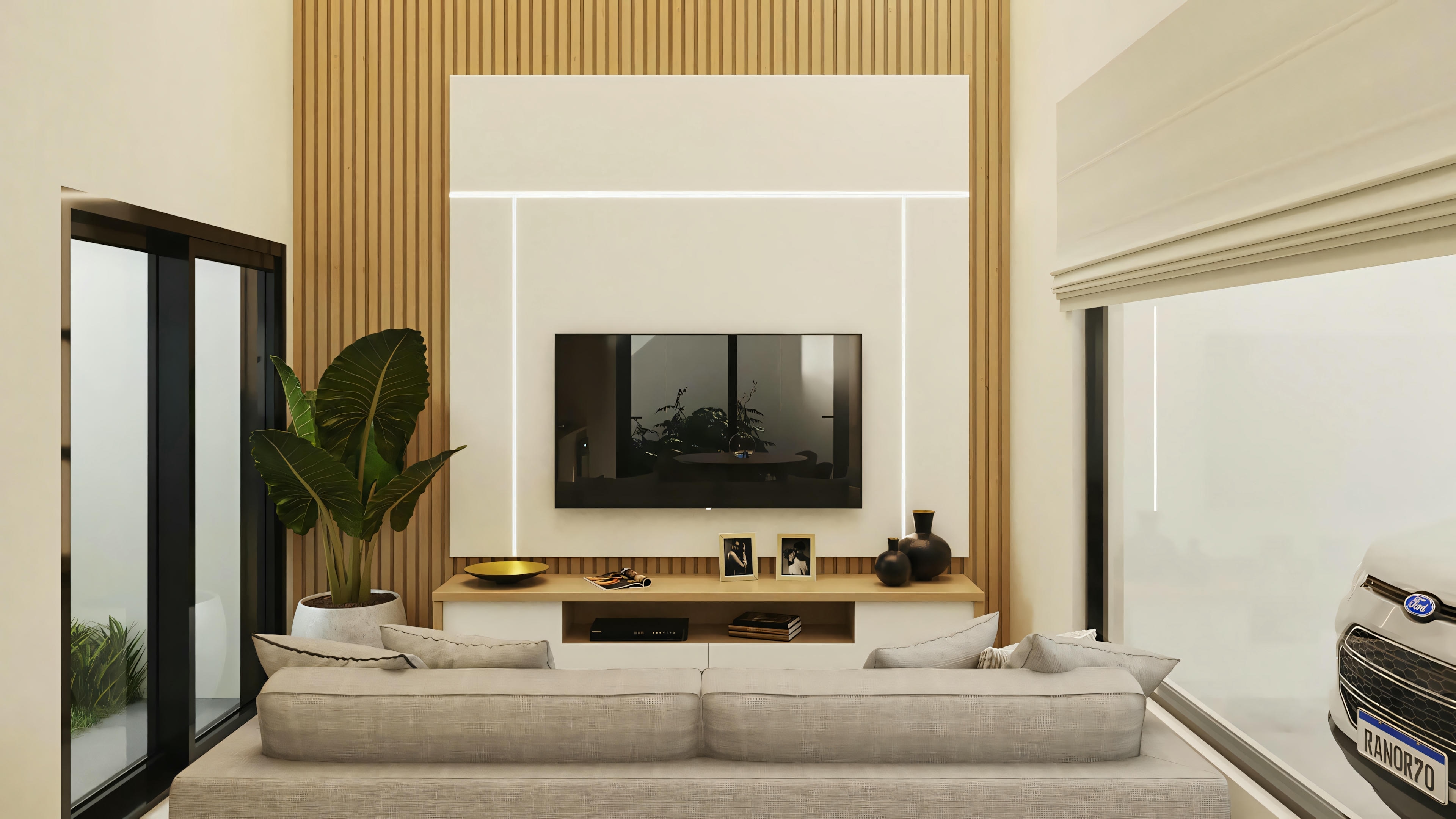 Sala de estar com sofá, mesa de centro, televisão montada na parede e plantas decorativas.
