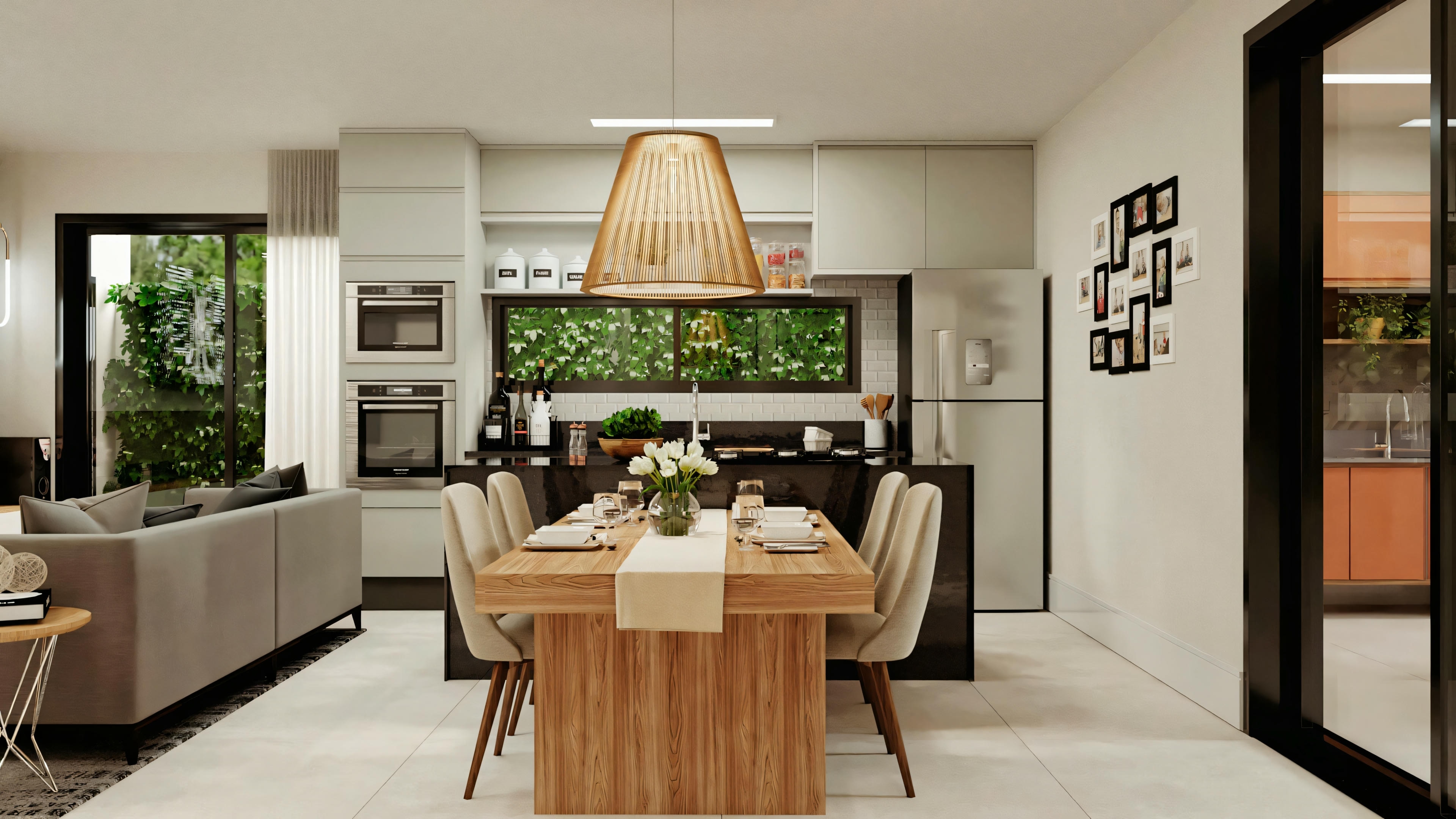 Dining area with wooden table for four people, modern pendant lighting above, and open plan layout leading to a living room with sofas in the background.