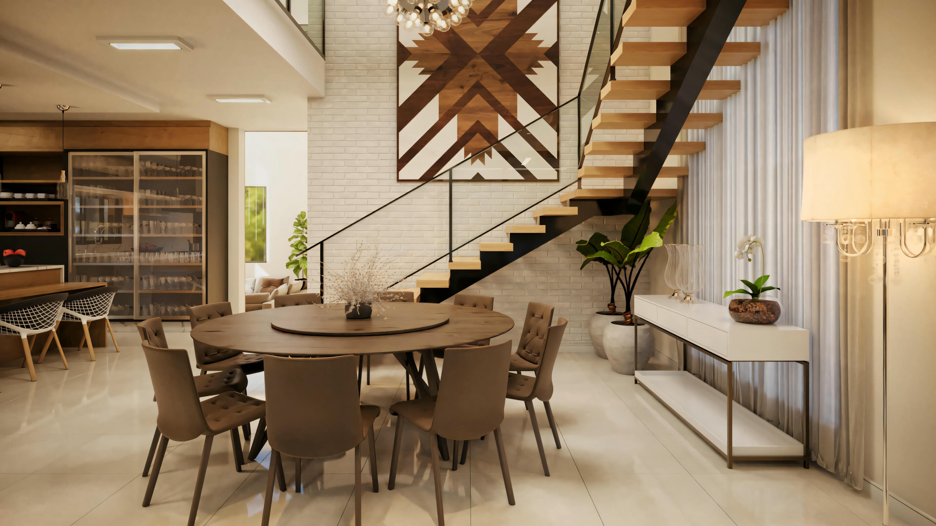 A dining area with a round table and chairs, adjacent to a staircase leading to the upper floor.