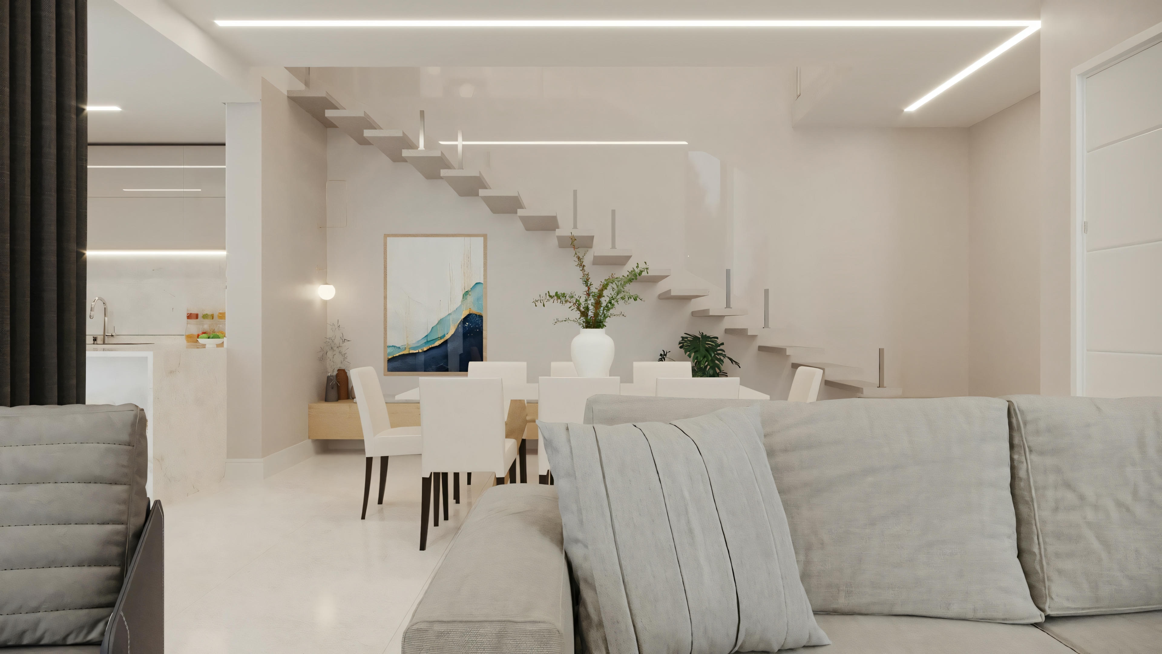 A spacious living room with a light-colored sofa, armchair, coffee table, and decorative pillows; in the background, stairs lead to another level.