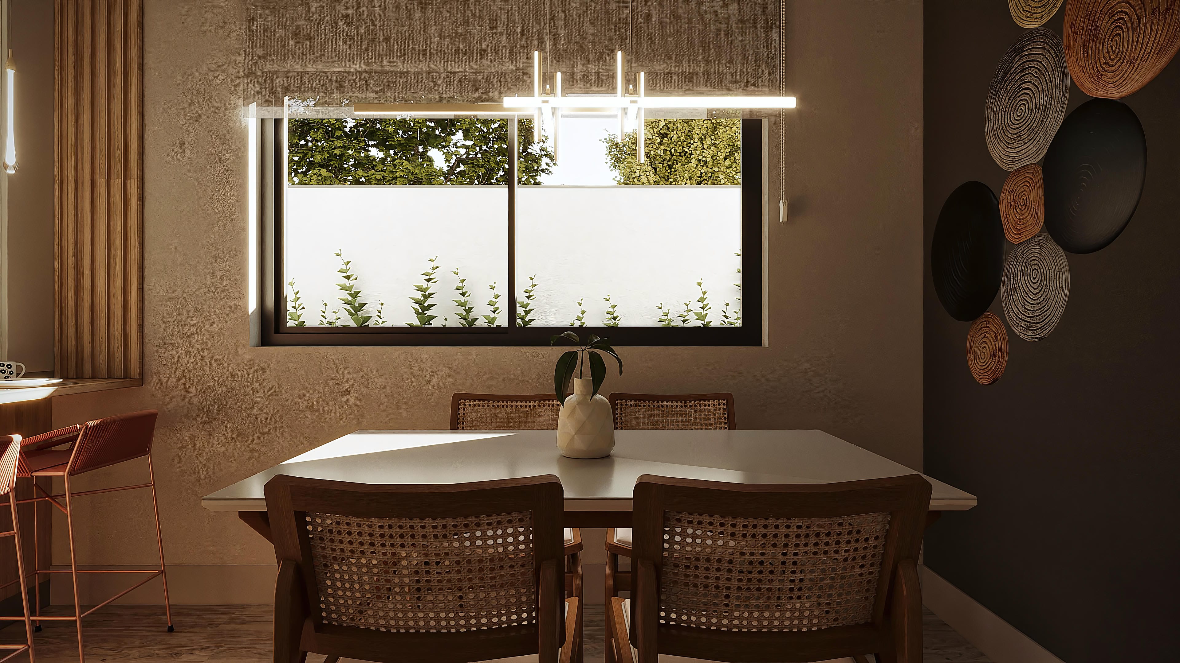 Dining room with a white table and wooden chairs with straw seats, decorated with a vase and plant, modern pendant lighting, and detailed wall cladding.