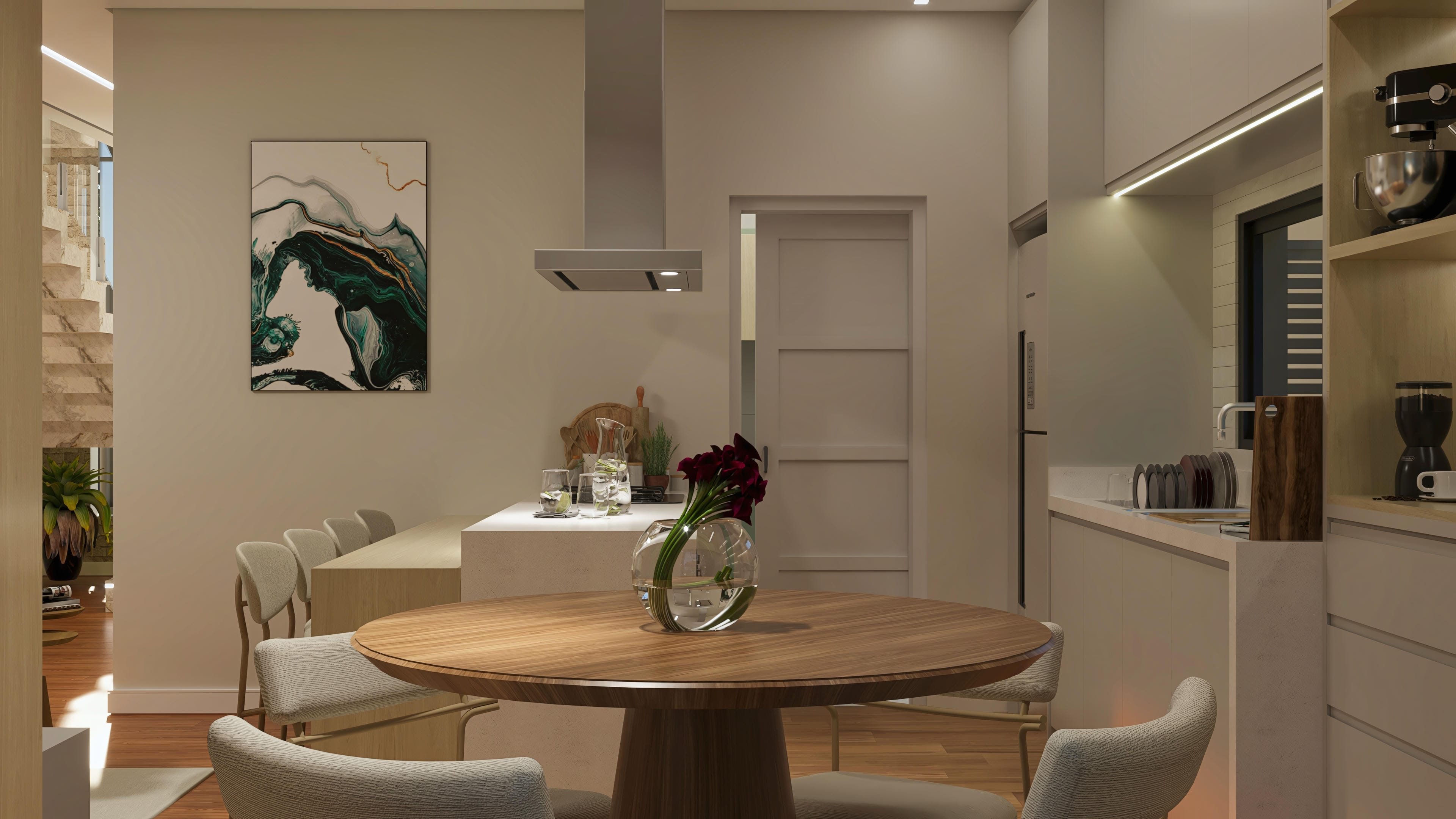 Dining room and kitchen integrated with a central island and counter, round wooden table and upholstered chairs, indirect lighting, and a decorative painting.