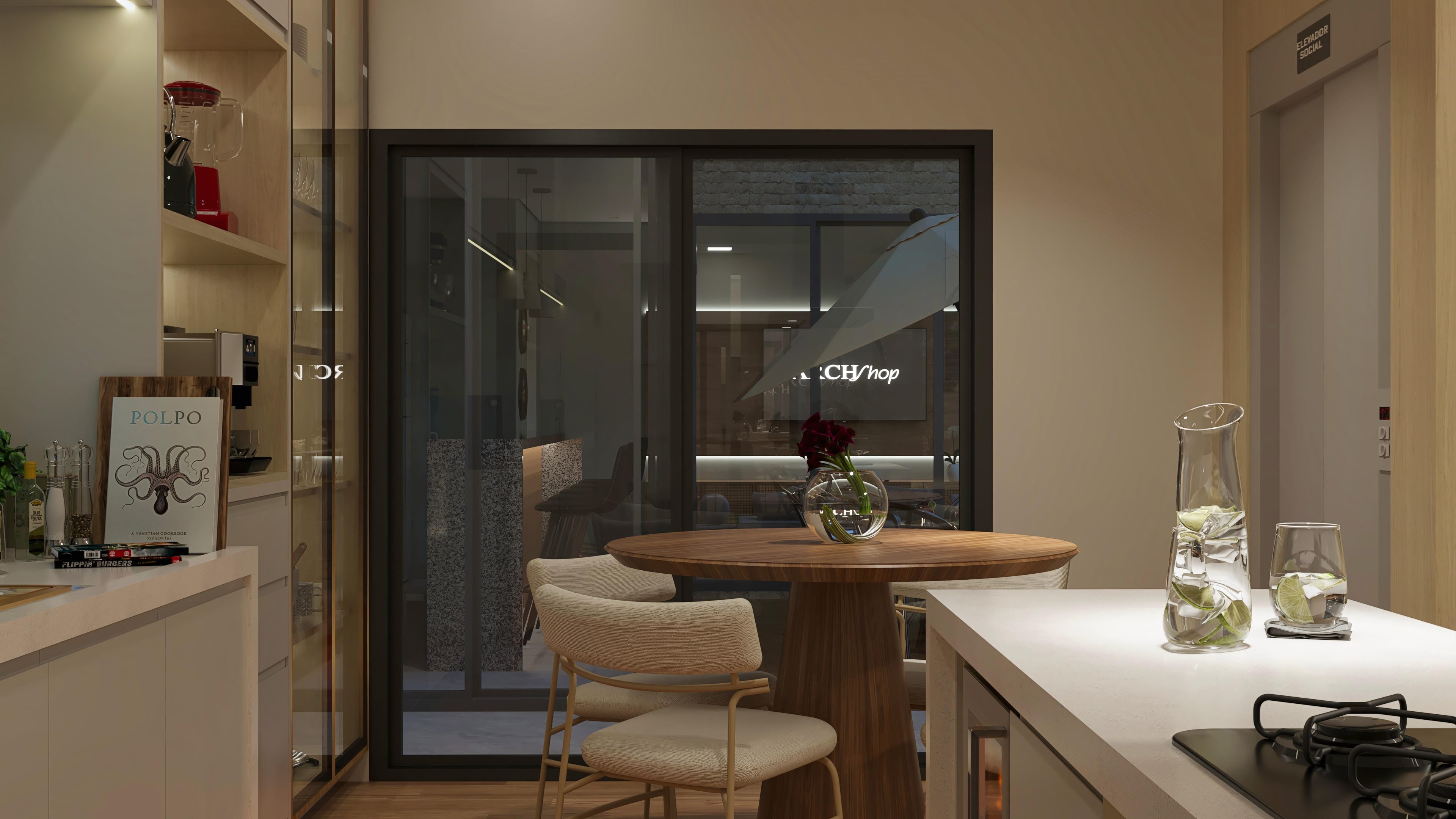 Interior of a modern kitchen with custom cabinets, an island with a light stone countertop, a round wooden dining table, and a view of the external gourmet area.