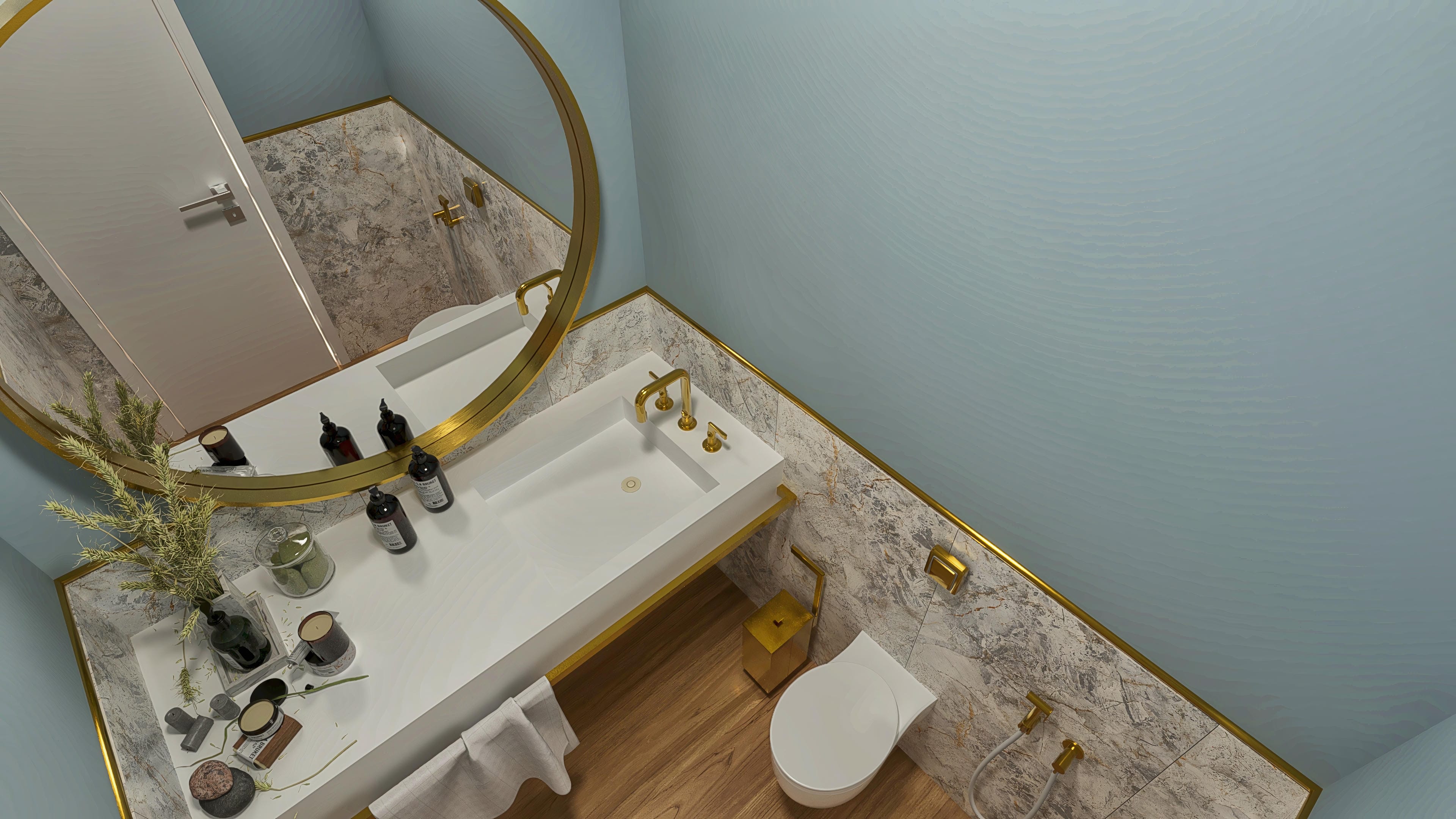 Banheiro moderno com pia de bancada branca e acabamentos dourados, espelho redondo dourado, paredes azul claro com textura e piso de madeira.