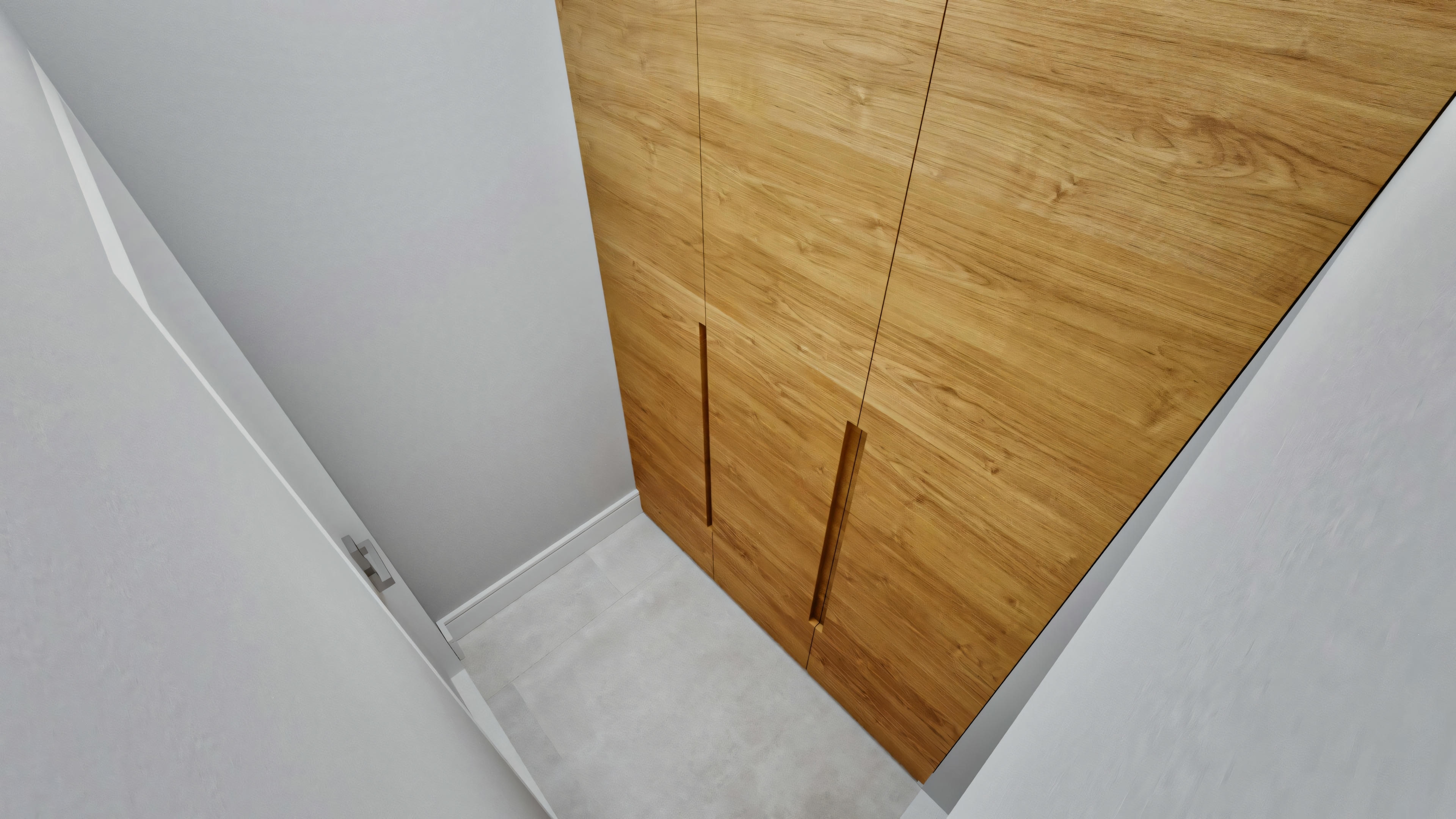 View from above of a room corner with light wood and white walls.