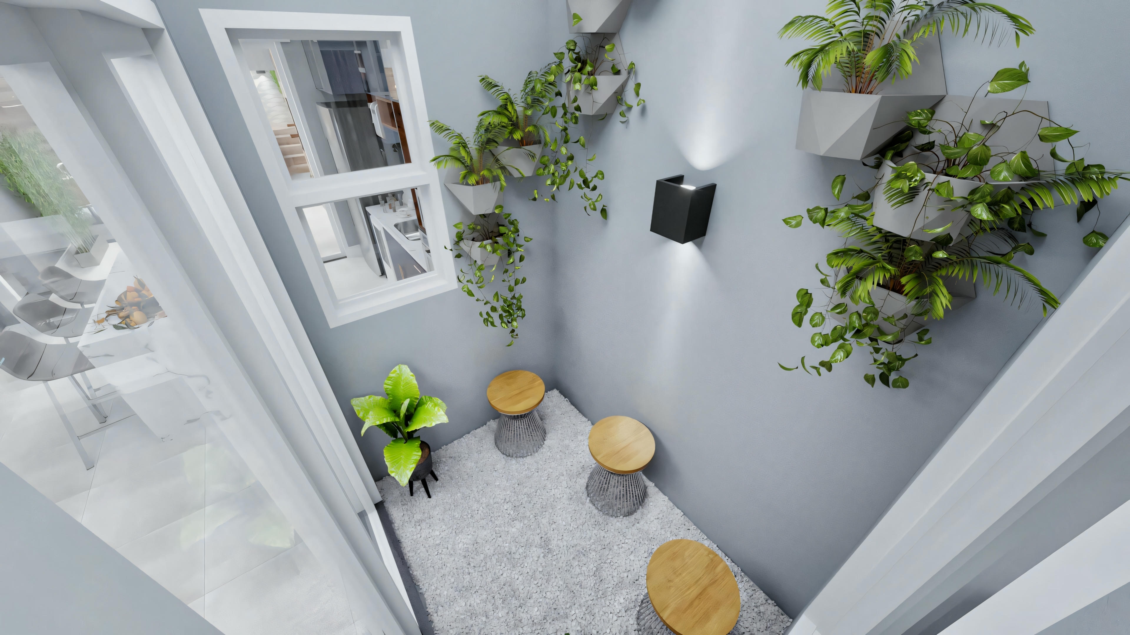 A kitchen corner with white walls, decorated with green plants, featuring a black countertop with yellow fruits and two stools.