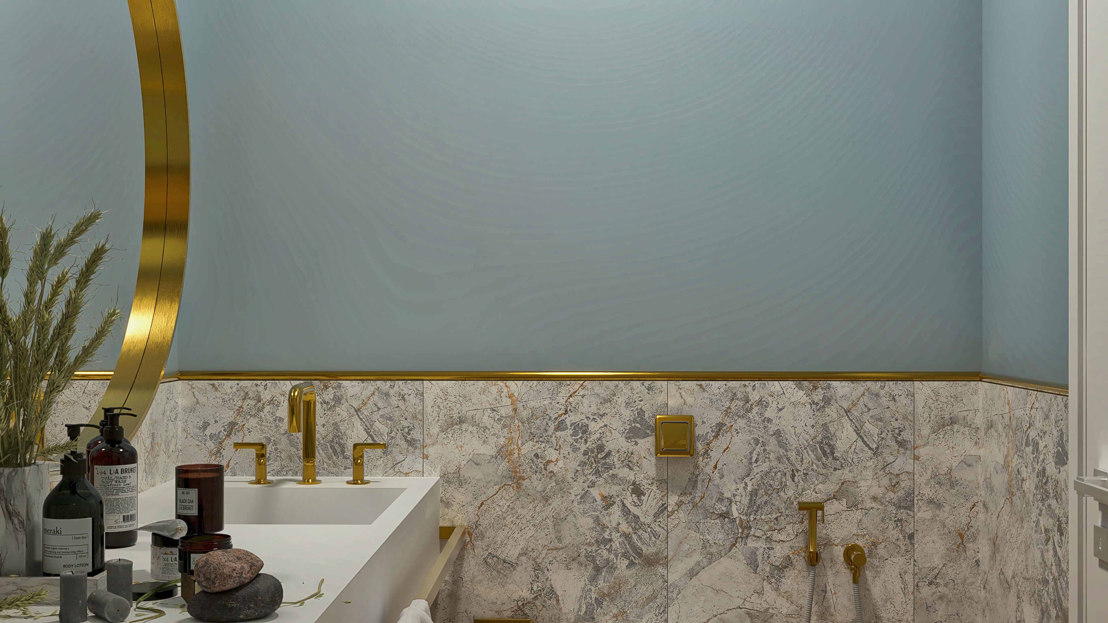 Detalhe de um banheiro com revestimento em mármore texturizado, detalhes em dourado polido e espelho curvo. As paredes superiores possuem um acabamento suave em tons de azul acinzentado.