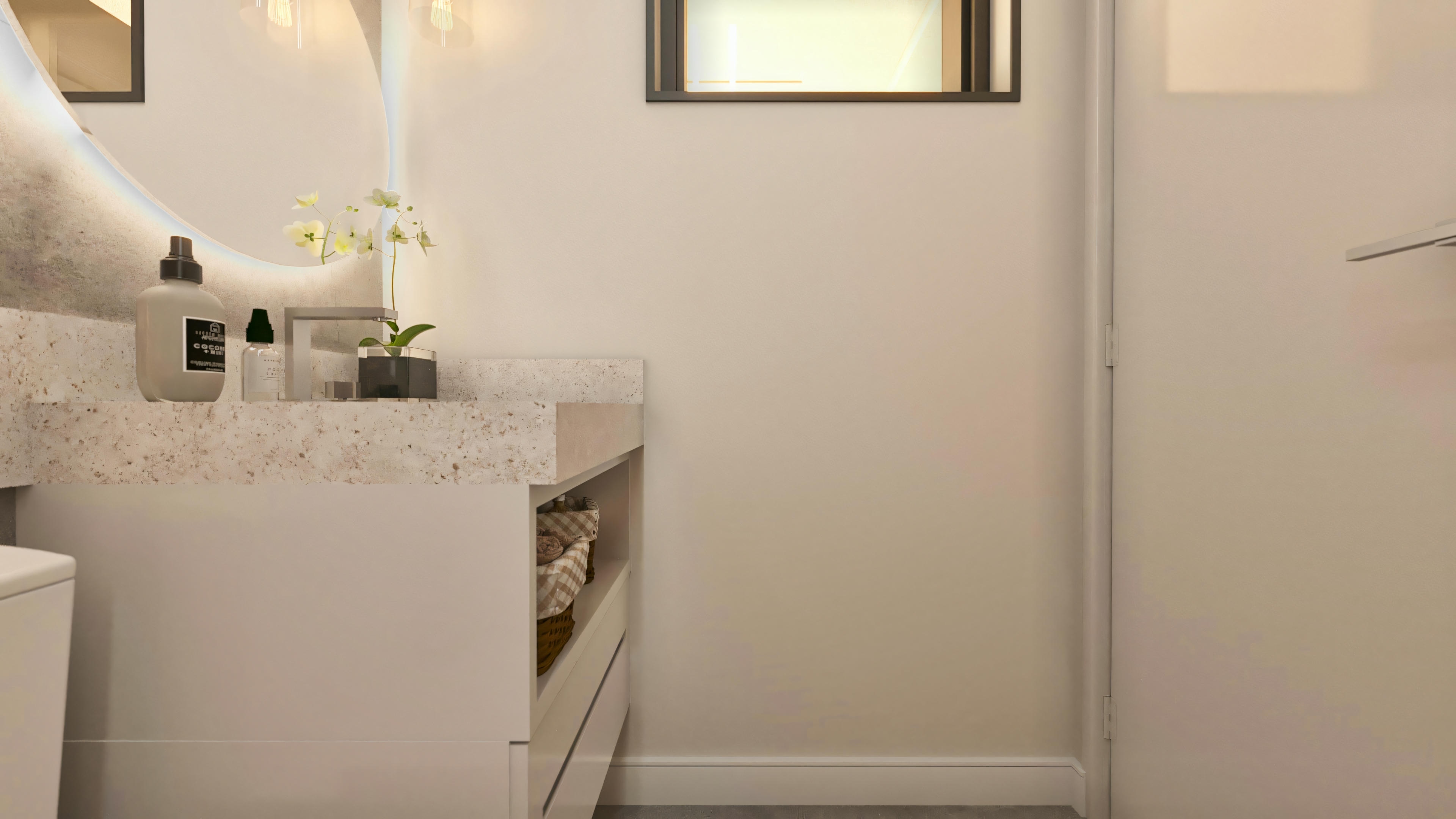 Baño de cortesía decorado en proyecto de casa moderna con 394.84m², 4 suites y 5 baños. Detalle de la mesada de piedra clara salpicada (granito o cuarzo), con lavamanos de apoyo o tallado, mueble blanco con cajón y nicho con cestos organizadores. Espejo redondo con iluminación LED indirecta, y objetos decorativos como jarrón con orquídeas blancas y frascos. Pared en tono neutro claro.