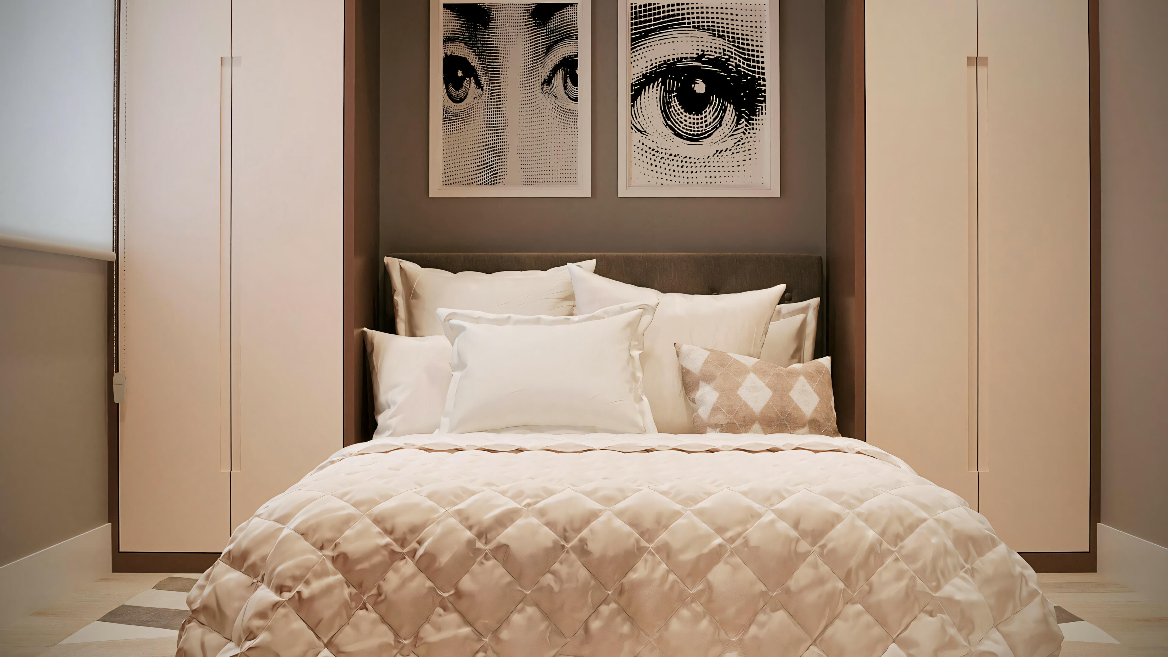 A bedroom with a large bed in the center, covered with a textured quilt.