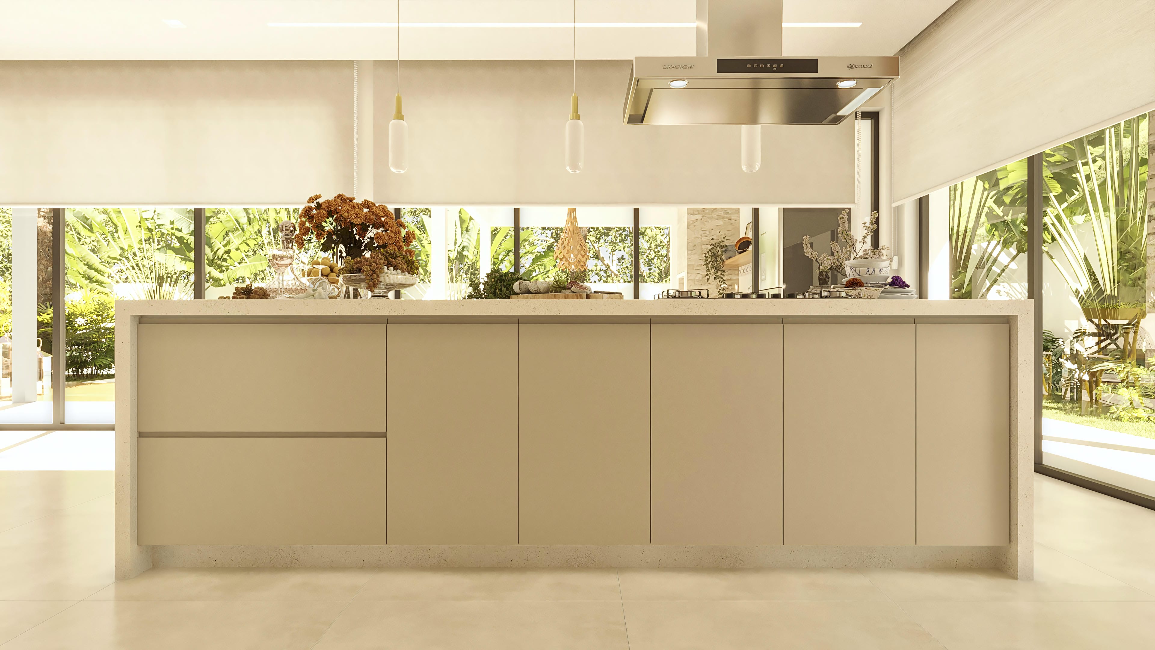 Internal view of a modern kitchen with a large island in neutral tones, integrated with a lush outdoor area through large windows. The clean design of the cabinets, the stone countertop, and the elegant pendants stand out.