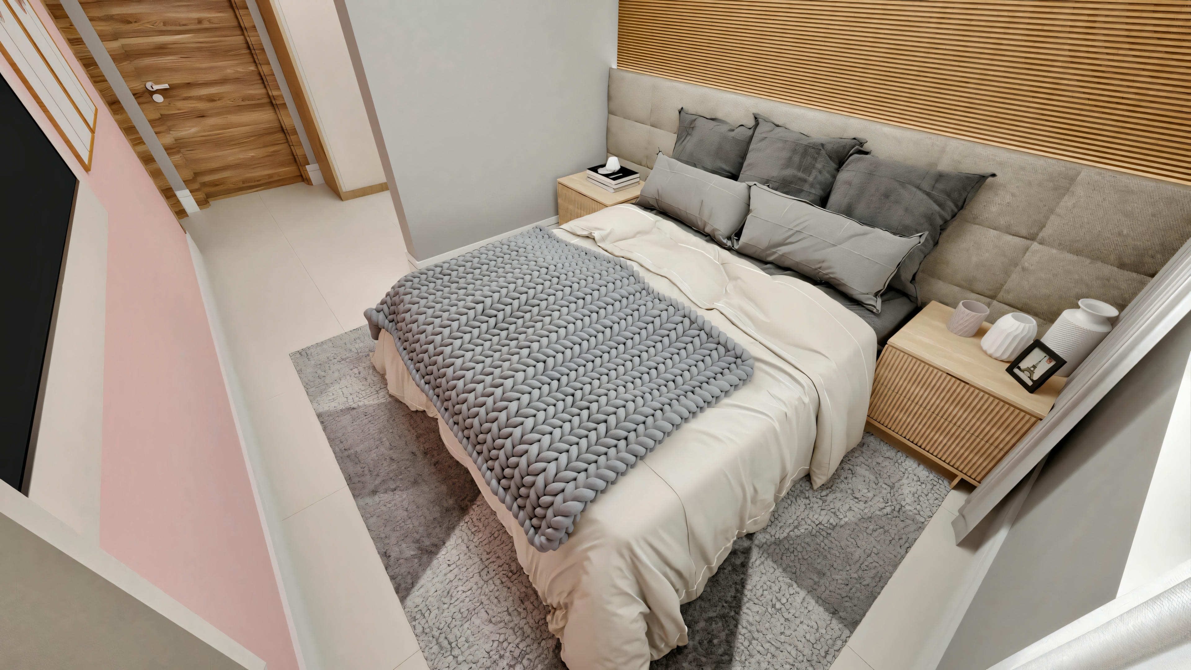 Vista angular superior do quarto de suíte em casa neoclássica, mostrando a cama com painel de madeira ripada sobre tapete cinza geométrico. Layout inclui mesas de cabeceira, porta de madeira e parte da parede rosa com TV. Uma das 4 suítes do projeto.