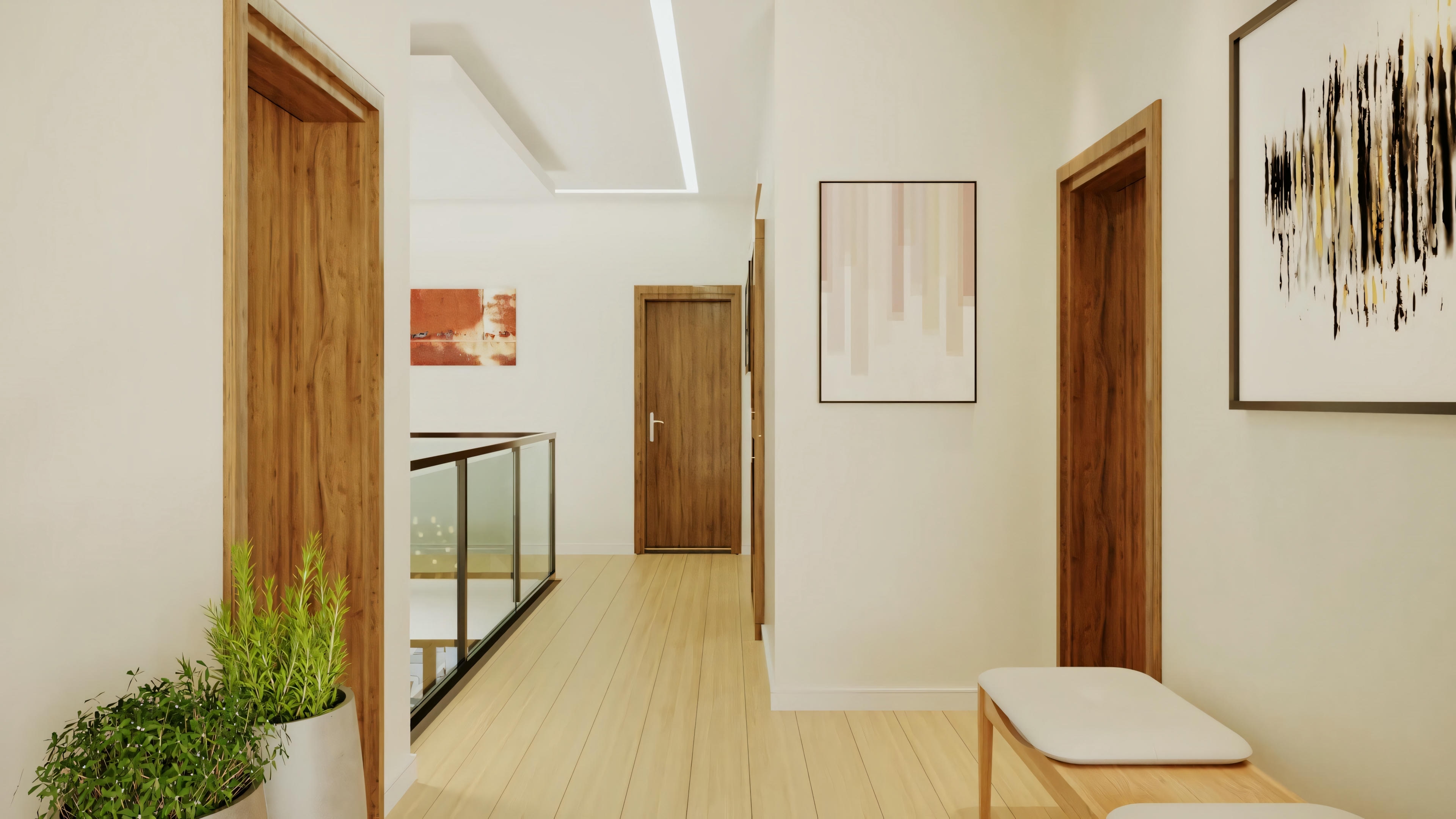 A hallway with a glass barrier, wooden floors, and white walls decorated with several framed art pieces.