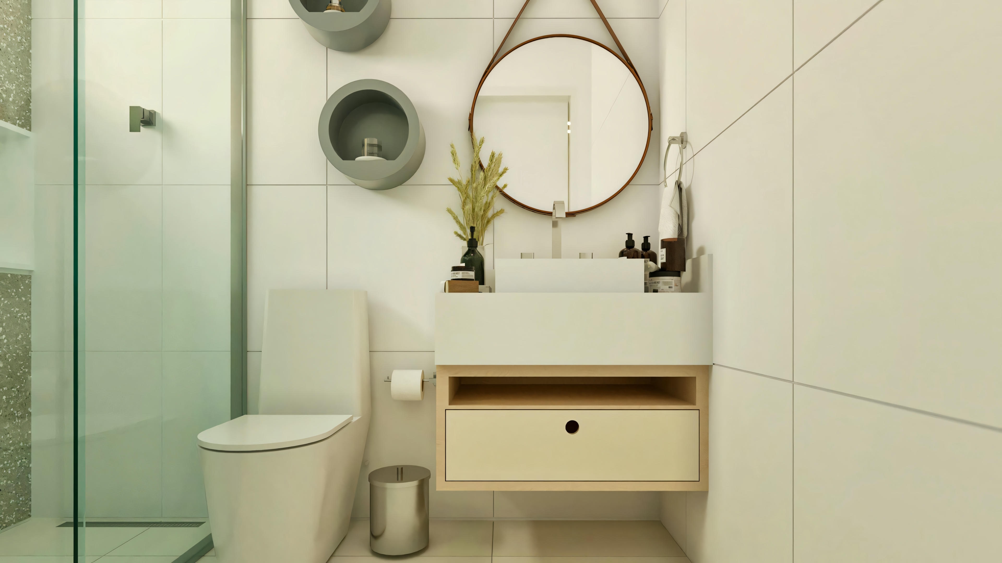 Baño de suite en casa de una planta de 3 habitaciones, con diseño moderno. Presenta inodoro blanco, box con vidrio templado, encimera suspendida clara con lavabo de apoyo rectangular y espejo redondo decorativo.