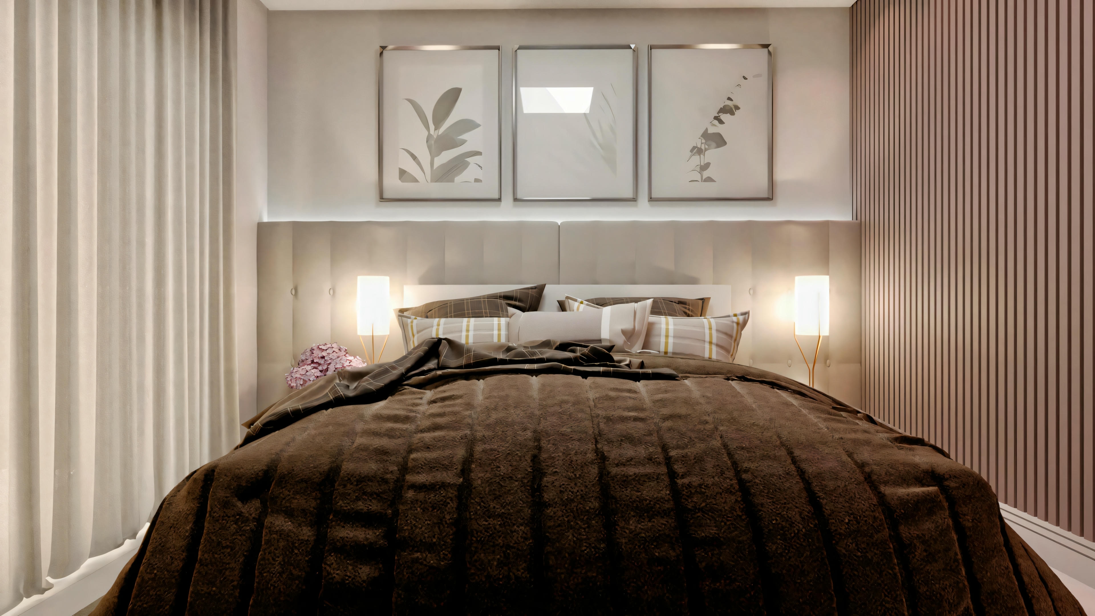 A bedroom with a dark quilt bed, nightstands with lamps, and two picture frames above the headboard.