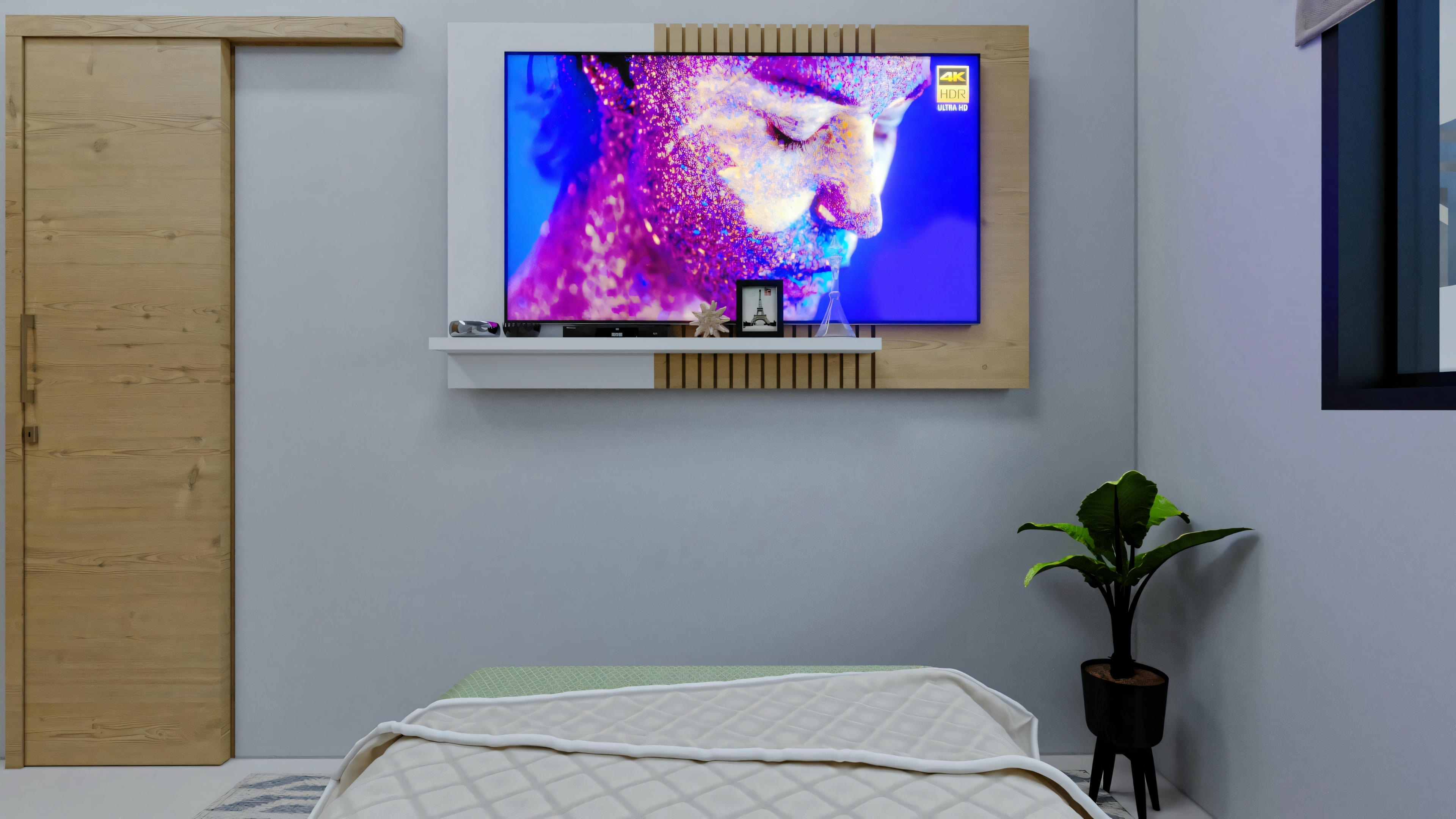 Un dormitorio con una cama grande, una televisión montada en la pared mostrando arte abstracto colorido y una planta en la esquina.