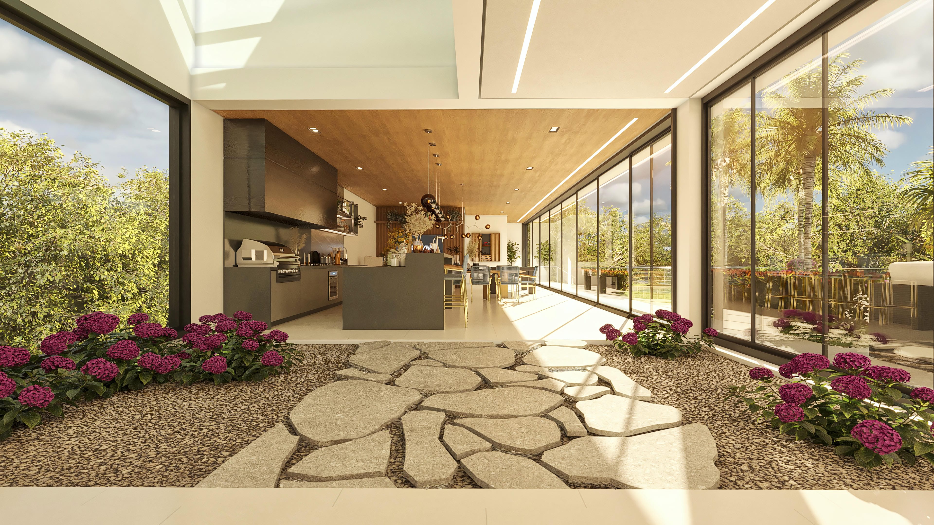 Interior view of a modern kitchen with a central island, integrated to a large dining room, with large glass windows connecting to lush outdoor landscaping and an inviting pool.