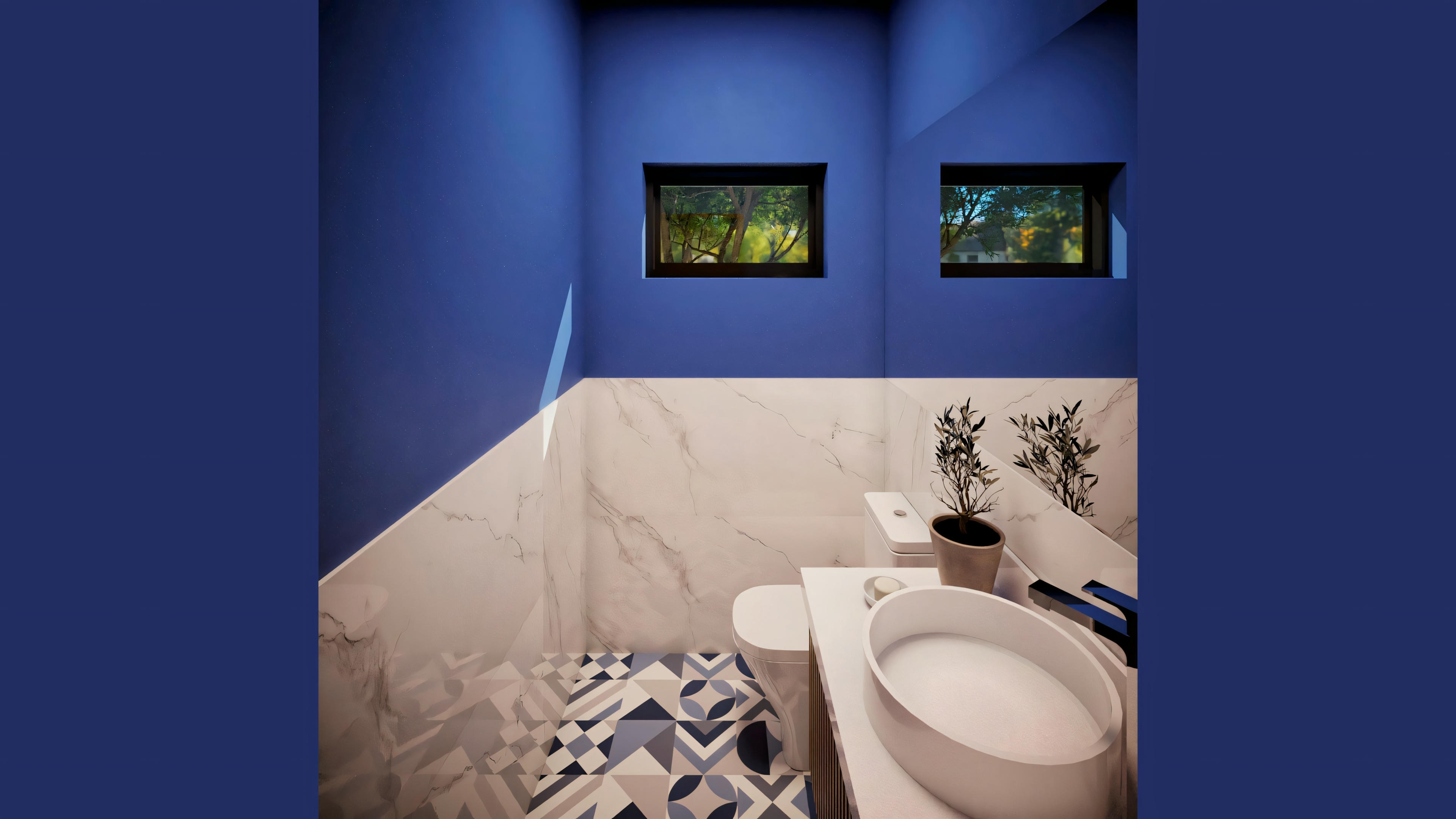 Bathroom with blue walls, toilet, sink, and decorative elements like frames and a plant.