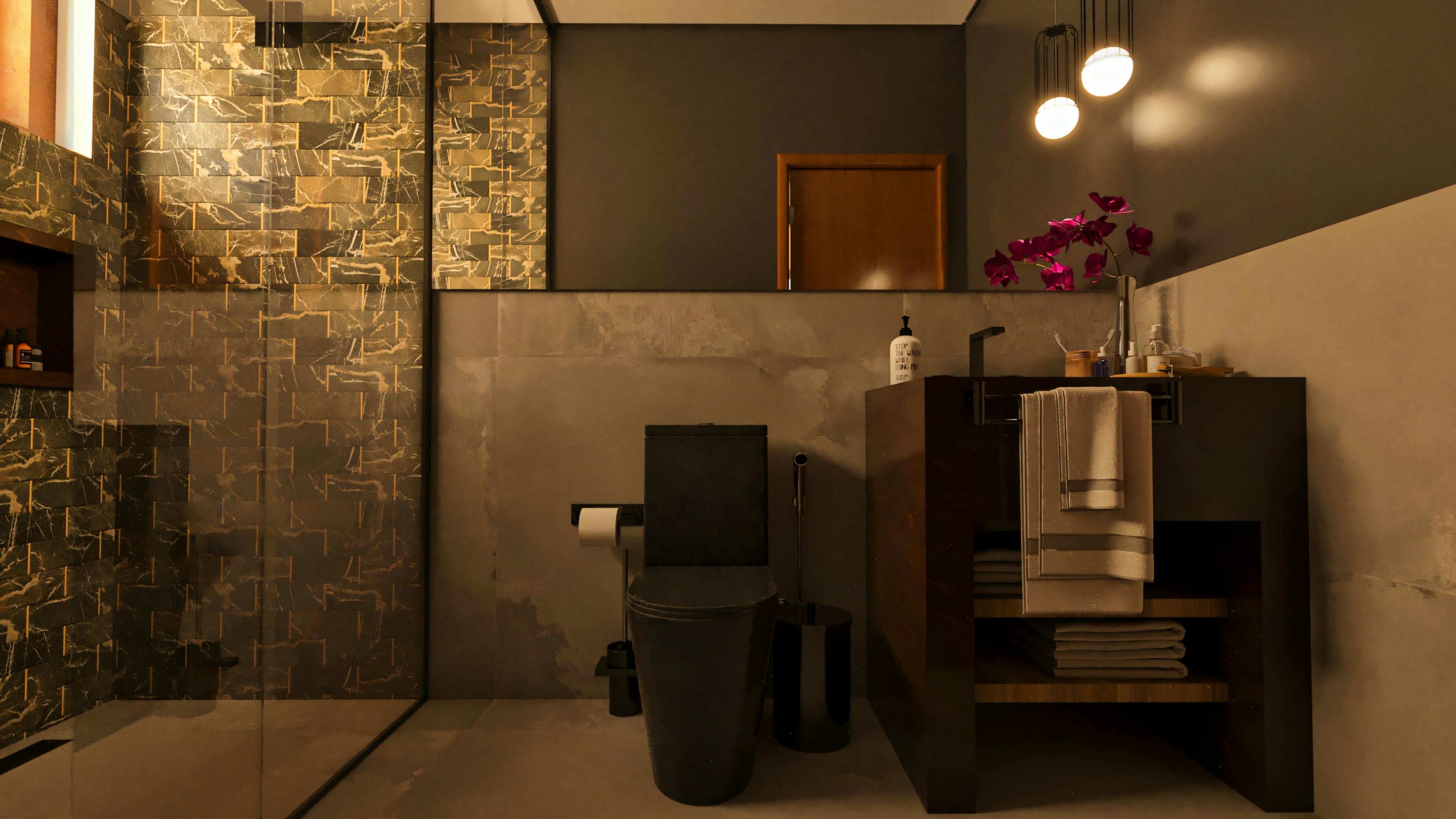 Baño de suite en casa de lujo con diseño moderno, presentando inodoro negro, encimera de madera oscura con lavabo sobrepuesto y toallas, espejo grande, lámparas colgantes y revestimiento de pared en tonos oscuros y dorados en el área de la ducha.