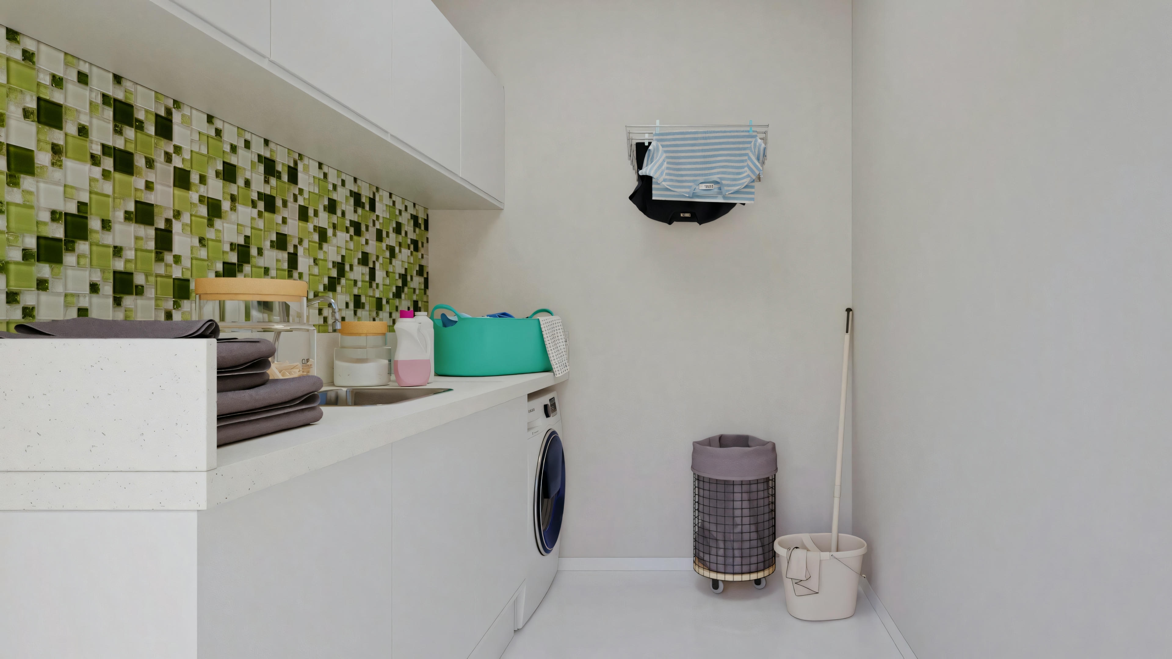 A laundry room with a green and white wall, a white sink with a blue towel, and various toiletries on the counter.
