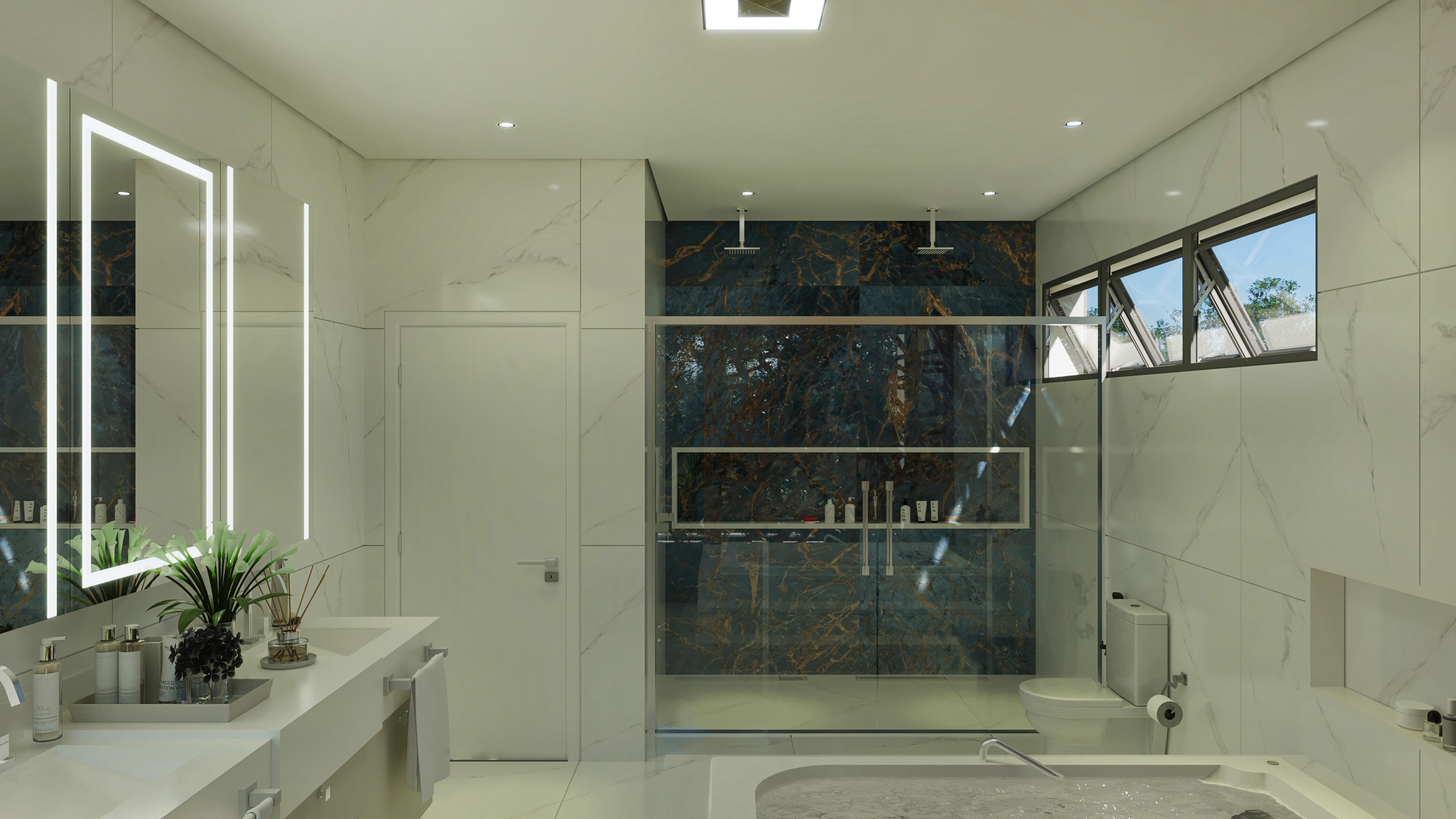 Baño de alto estándar con extensa encimera, espejo iluminado y ducha con revestimiento en mármol exótico.