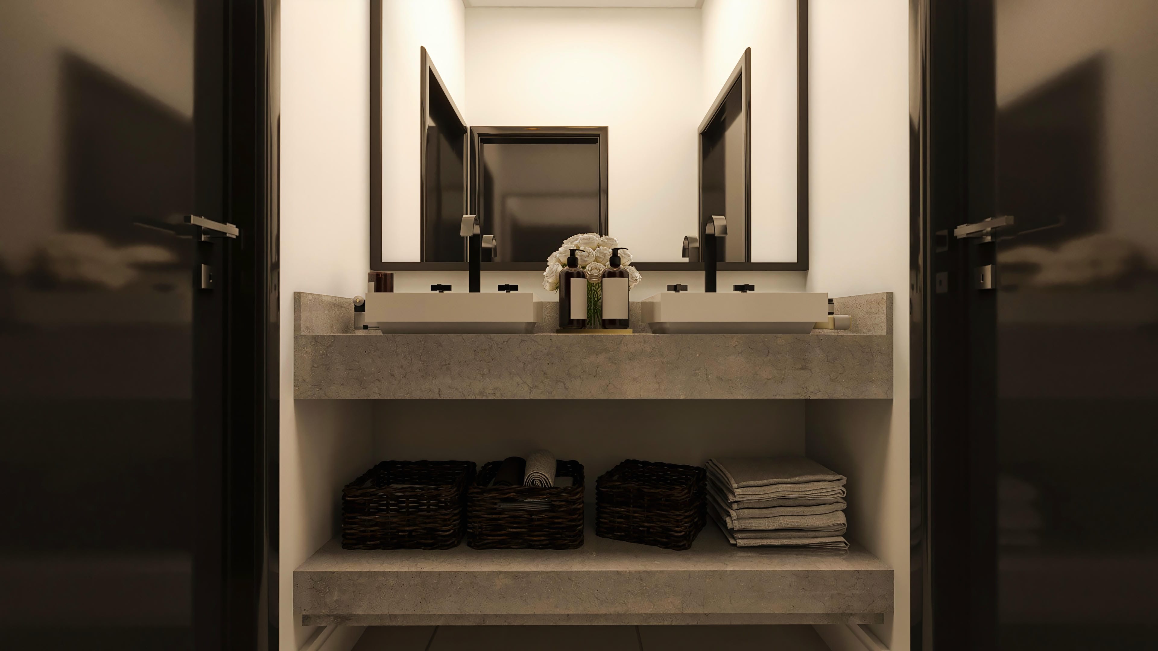 Exposed concrete bathroom counter with two vessel sinks and black faucets. Large mirrors and organizing baskets.
