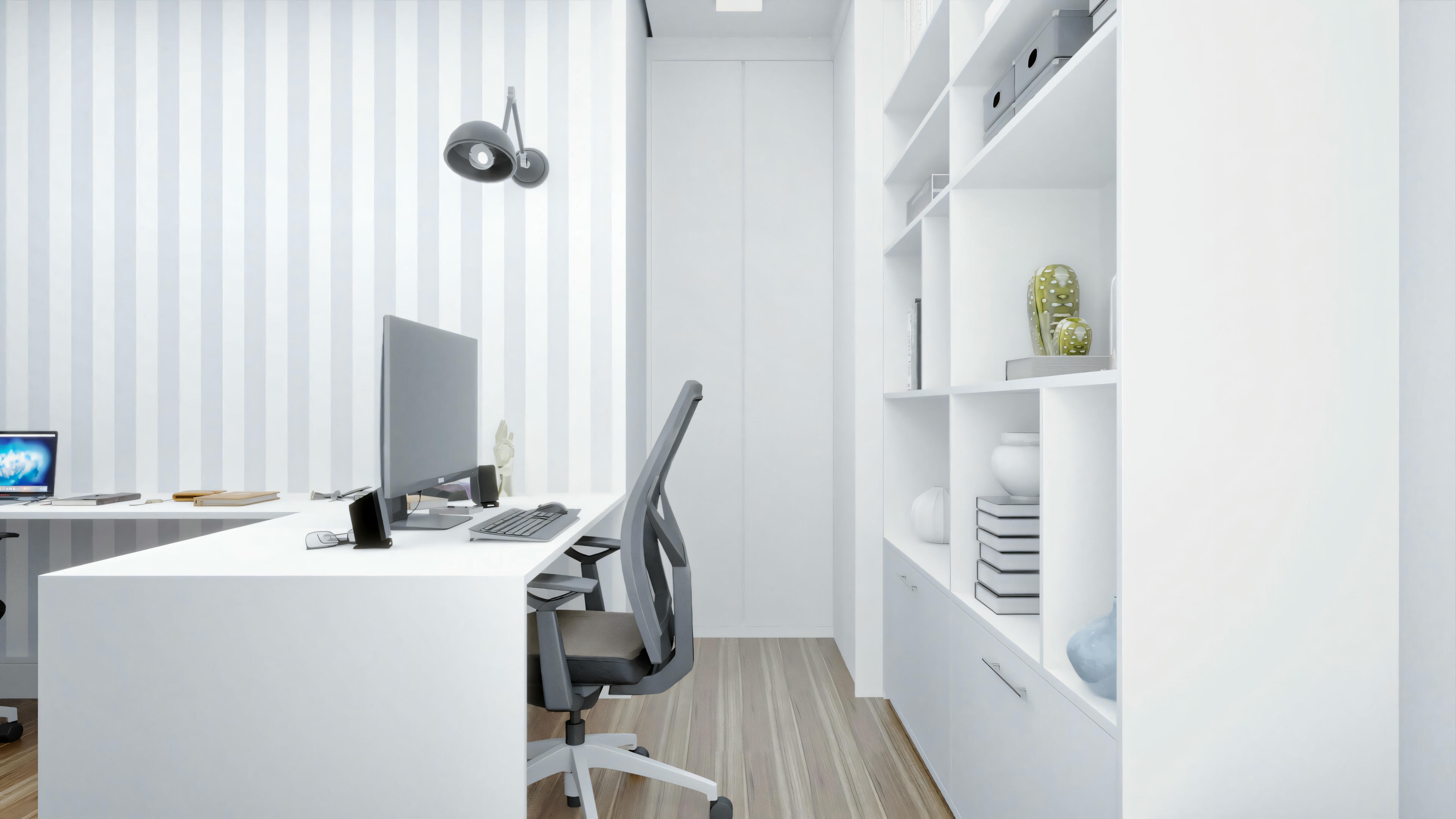 Interior space with a white desk and a desktop computer, including monitor, keyboard, and mouse. There is a window with partially open blinds allowing natural light to enter.