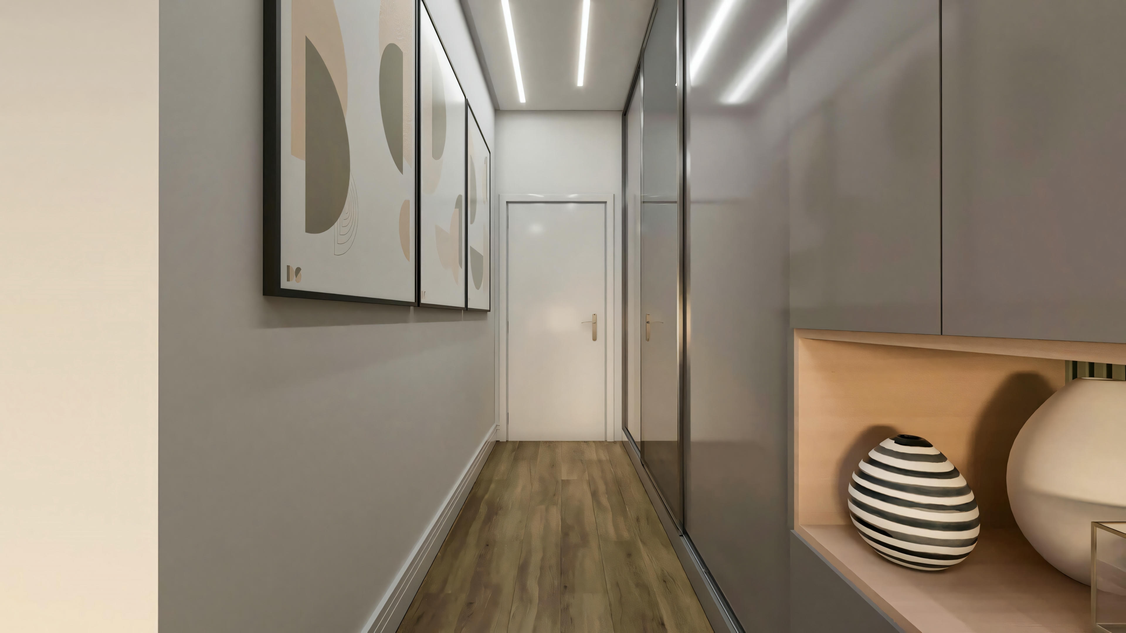 Corredor de circulação íntima no pavimento superior do sobrado de 194.7m² (lote 10x25). Ambiente com piso estilo madeira, armários planejados com nicho, iluminação embutida no teto e decoração com quadros.
