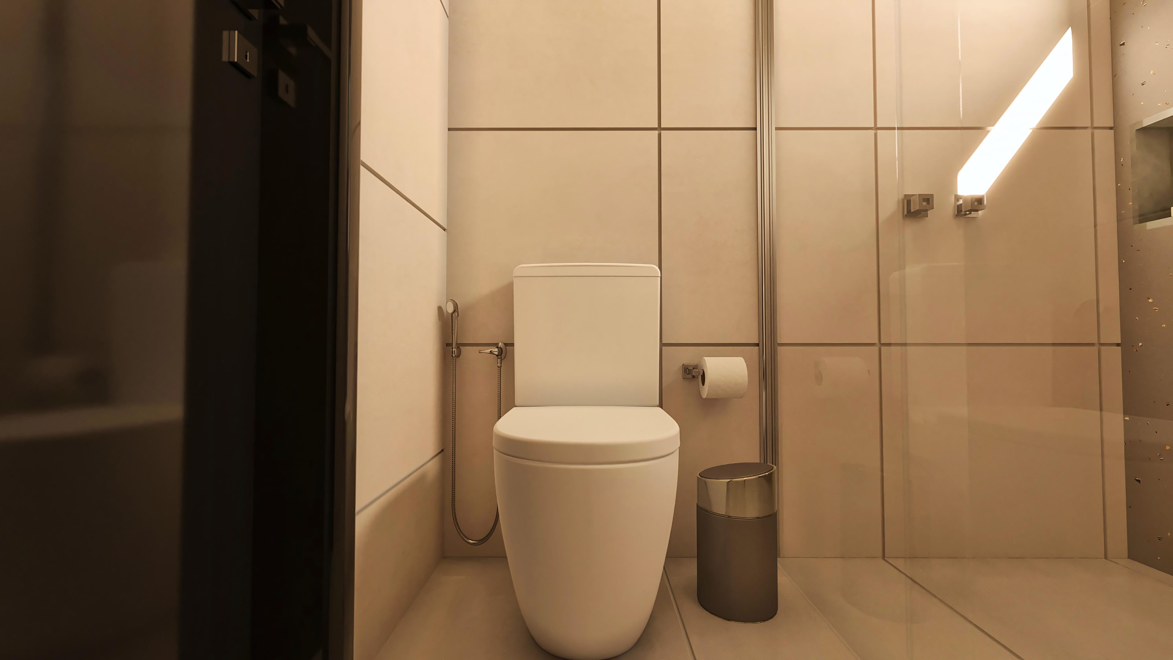 Banheiro com vaso sanitário branco, lixeira moderna e revestimento claro nas paredes com linhas discretas.