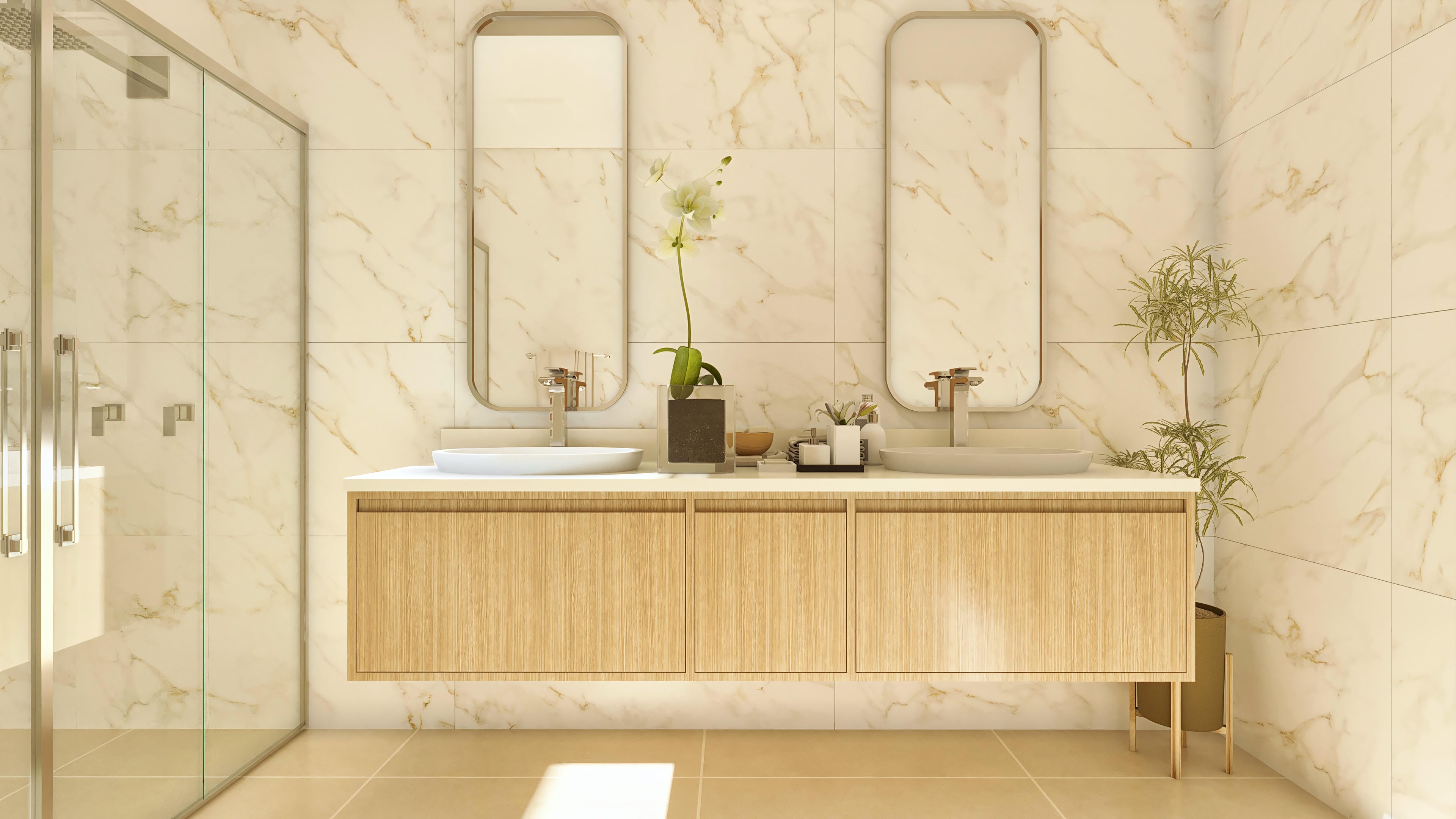 Baño moderno con revestimiento en mármol crema, dos lavabos de sobreponer blancos y encimera suspendida en madera clara.