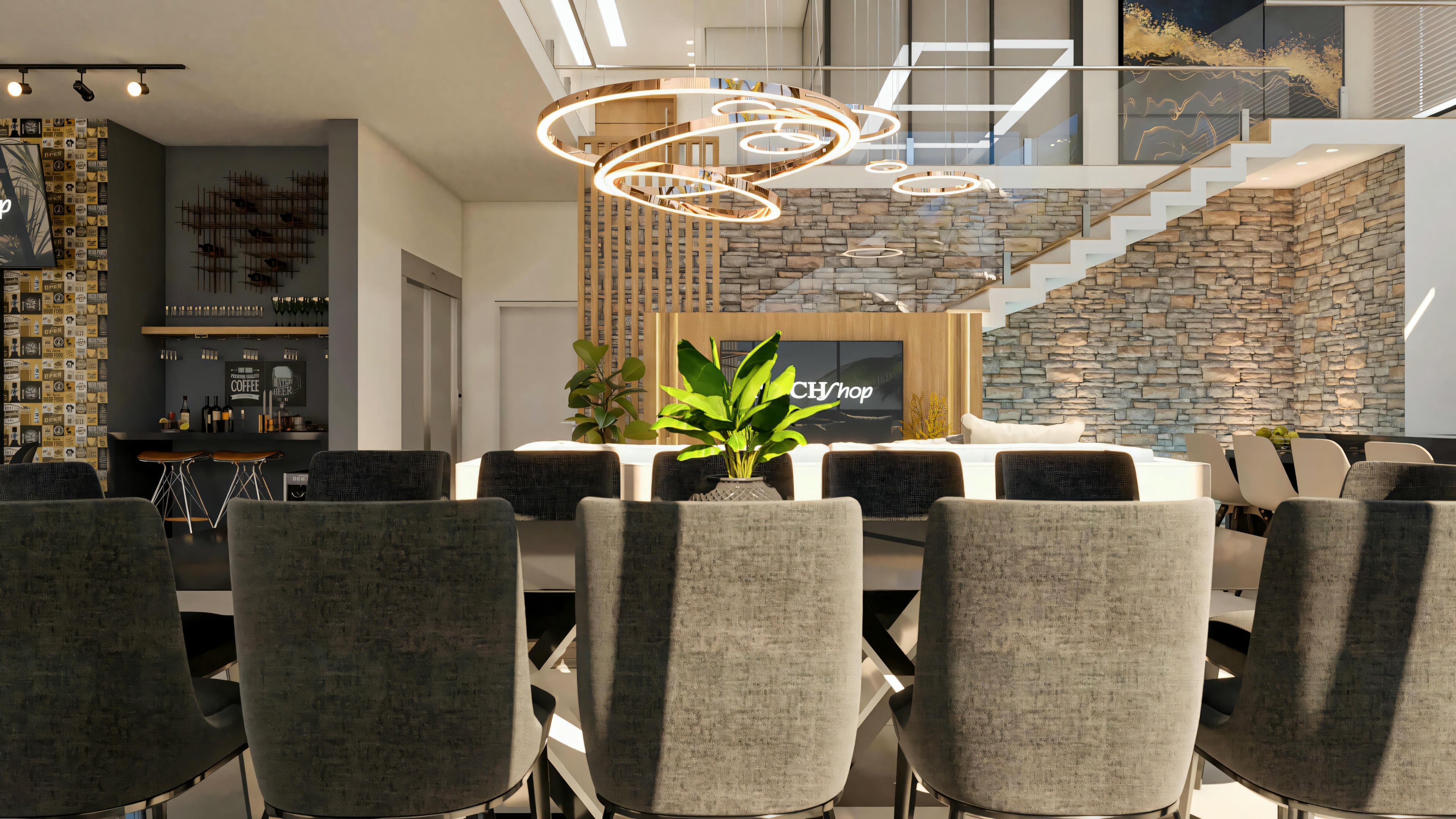 Integrated social area of the ready-made project with 5 suites, showing a dining room with a modern chandelier, TV room, staircase with a stone wall, and gourmet area in the background.