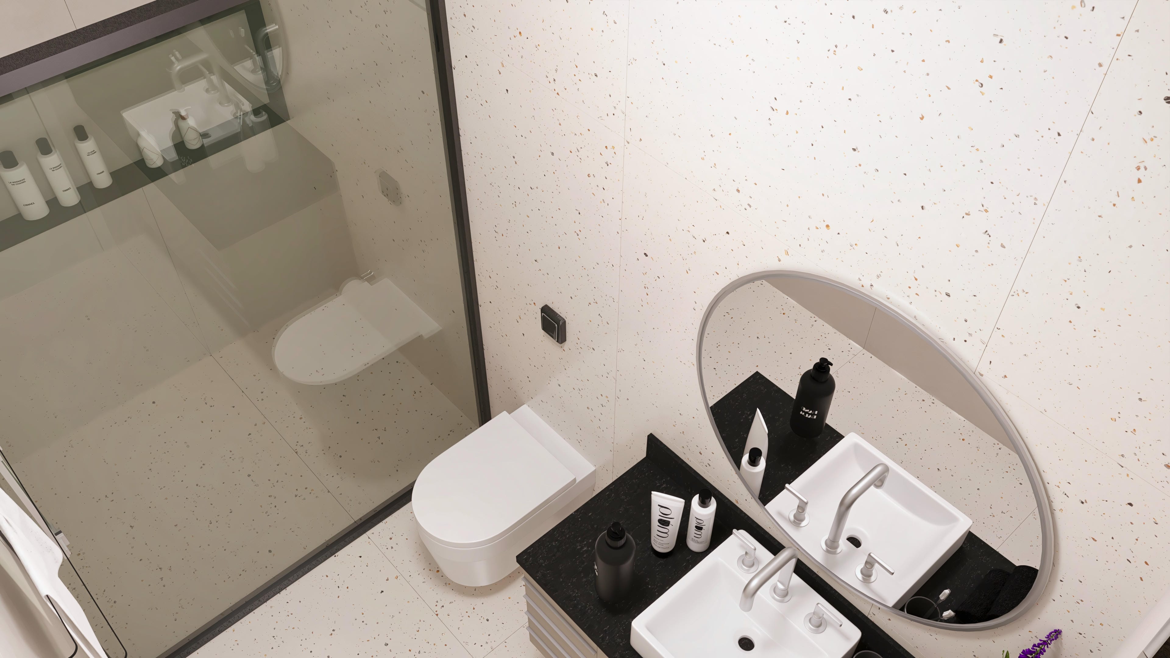 Interior de un baño moderno, destacando el revestimiento en terrazo claro en las paredes y suelo, encimera oscura con lavabo doble y espejo ovalado.