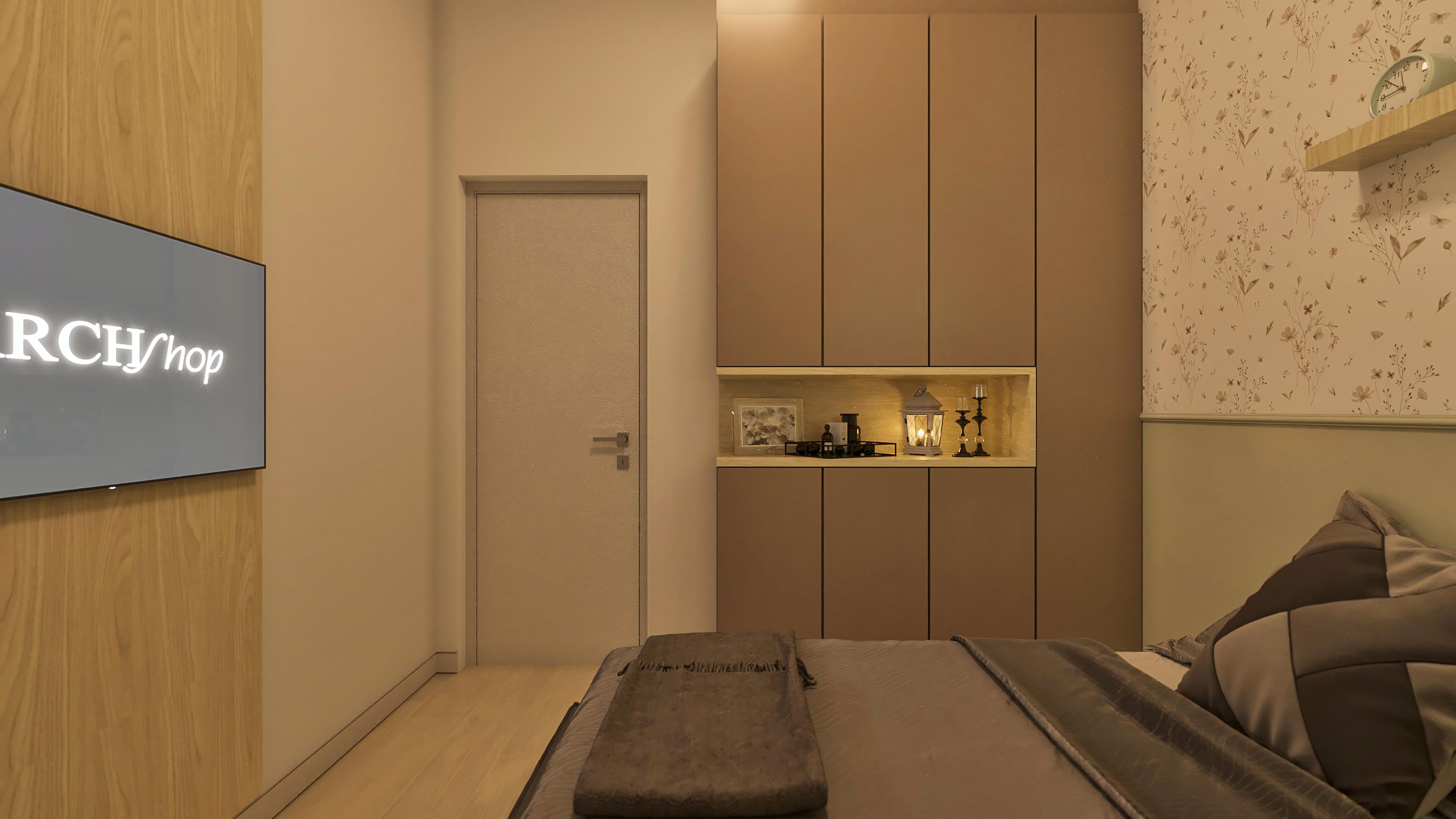 Interior de habitación moderna con pared revestida en madera clara, armarios integrales marrones, papel tapiz floral delicado y zócalo blanco. Detalle de puerta en tono neutro y lámpara decorativa.