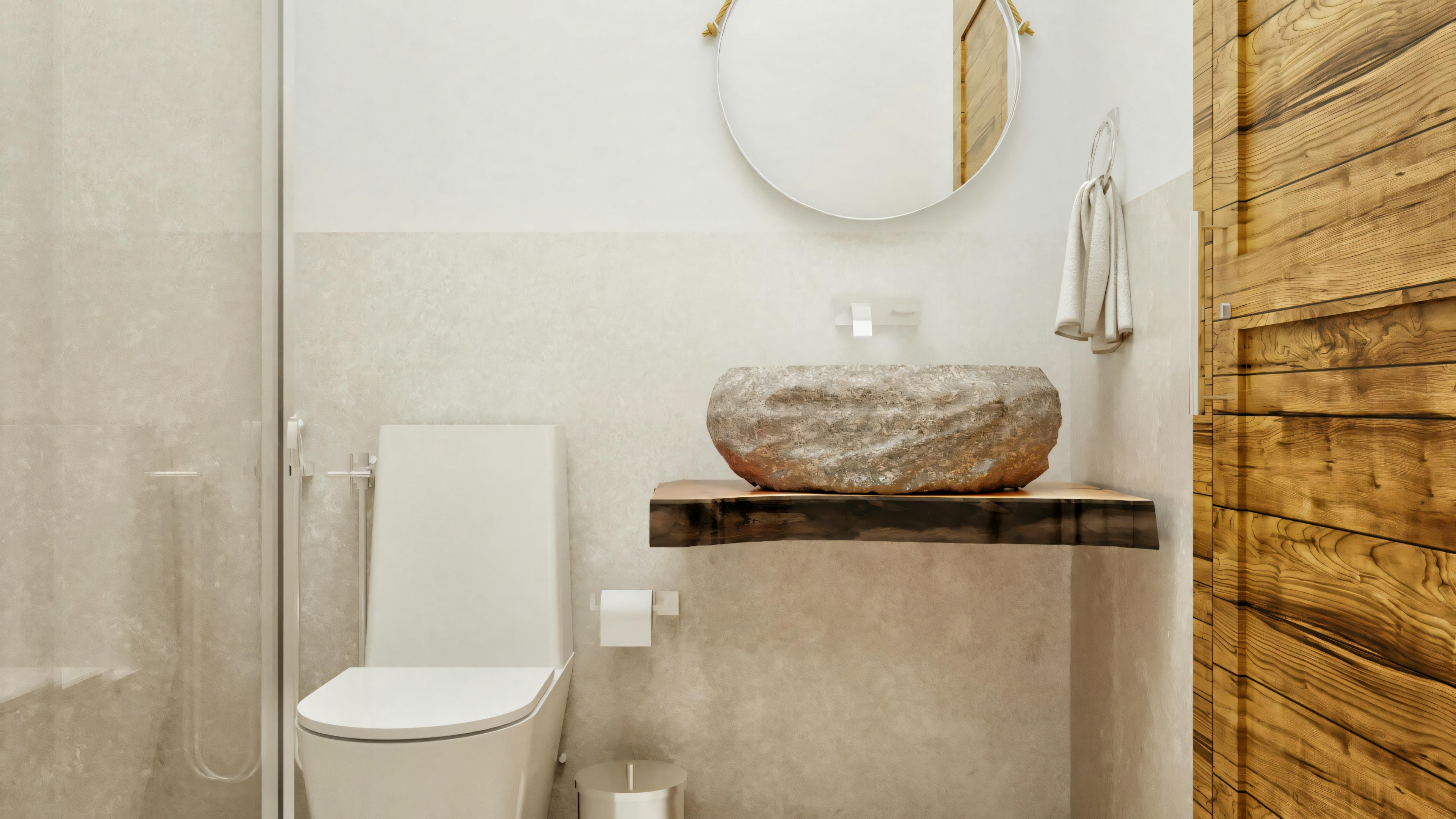 Baño de una de las suites o aseo de la casa de planta baja moderna con 4 suites, presentando lavabo de piedra natural sobre encimera de madera de demolición, puerta de madera y espejo redondo.