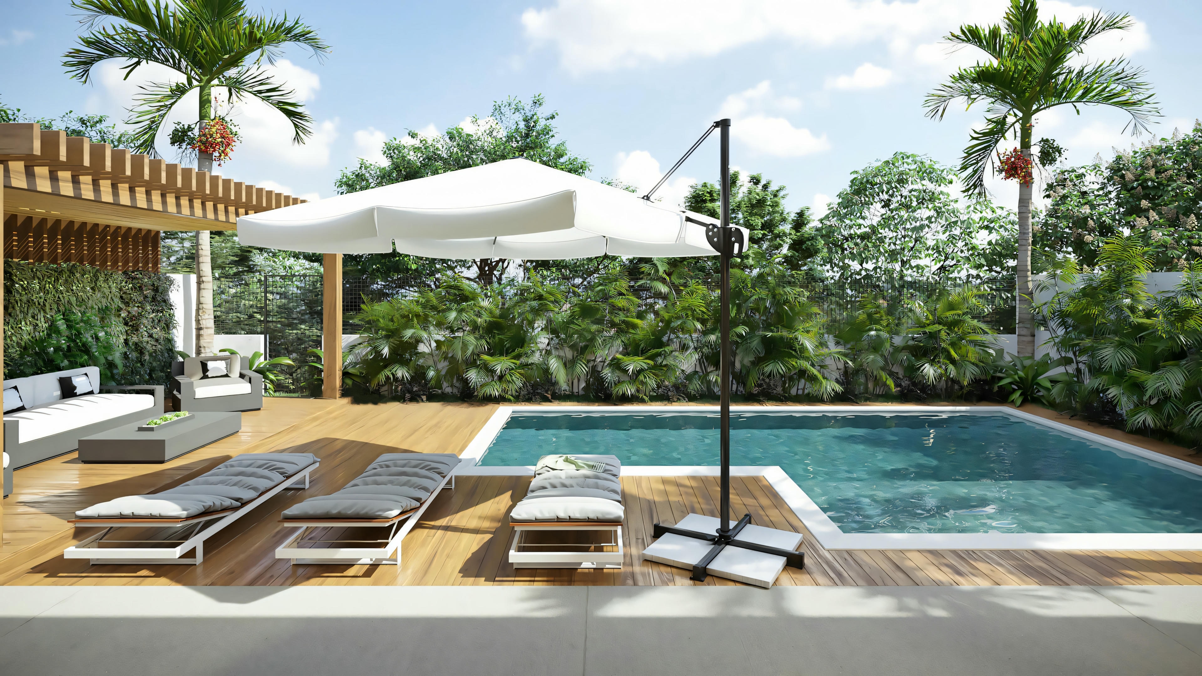 Outdoor pool area with lounge chairs under an umbrella, surrounded by lush greenery.