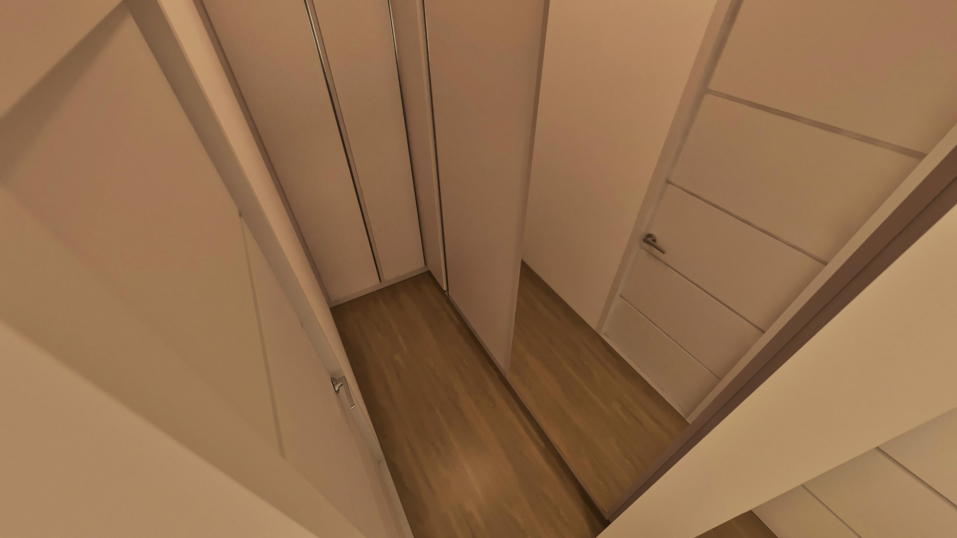 Detalle interno de una casa de una planta moderna, con suelo laminado de madera clara y puertas internas con diseño limpio y tiradores discretos.
