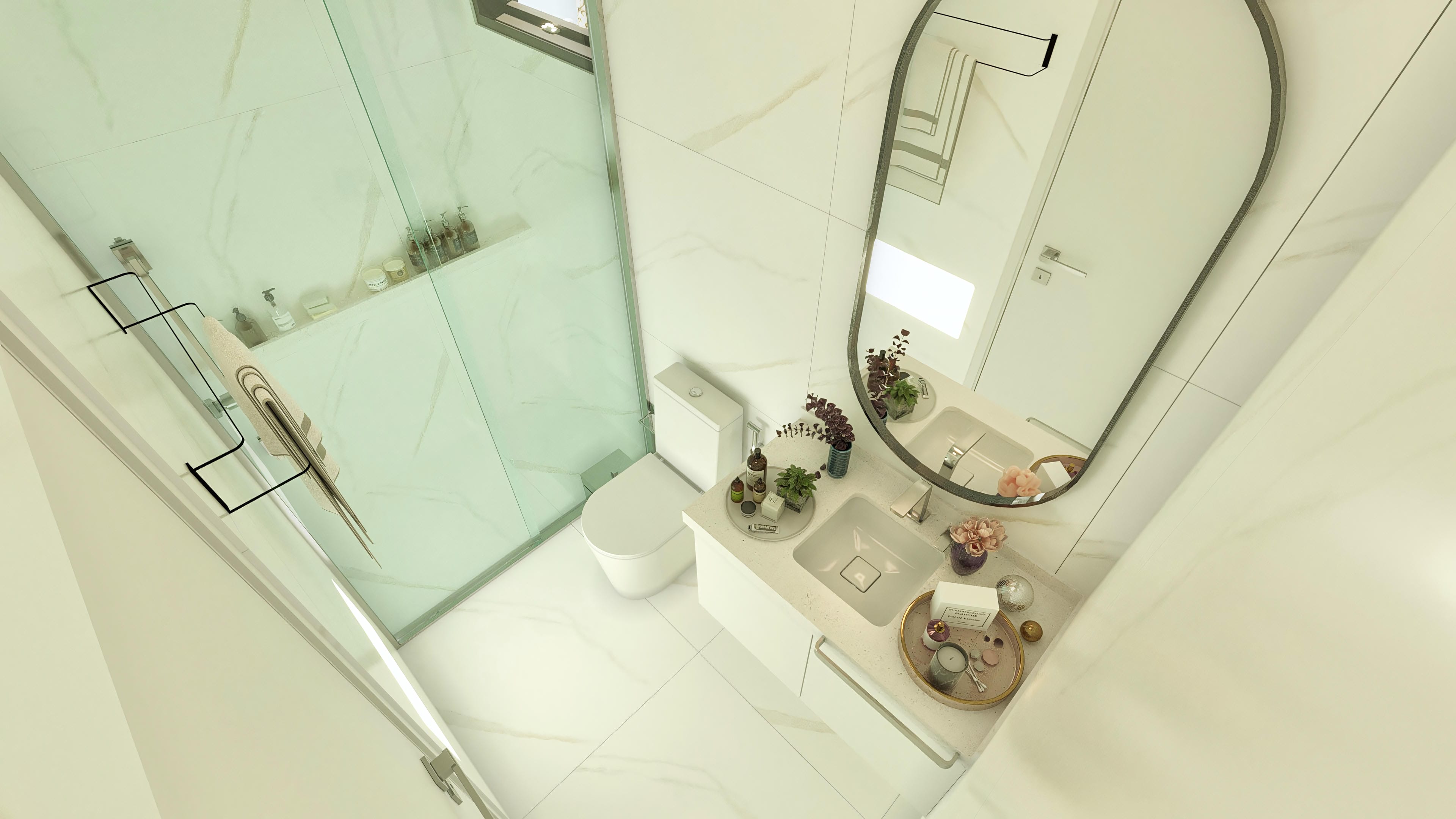 Bathroom with light-toned marbled cladding, tempered glass shower enclosure, and counter with two sinks and an oval mirror.