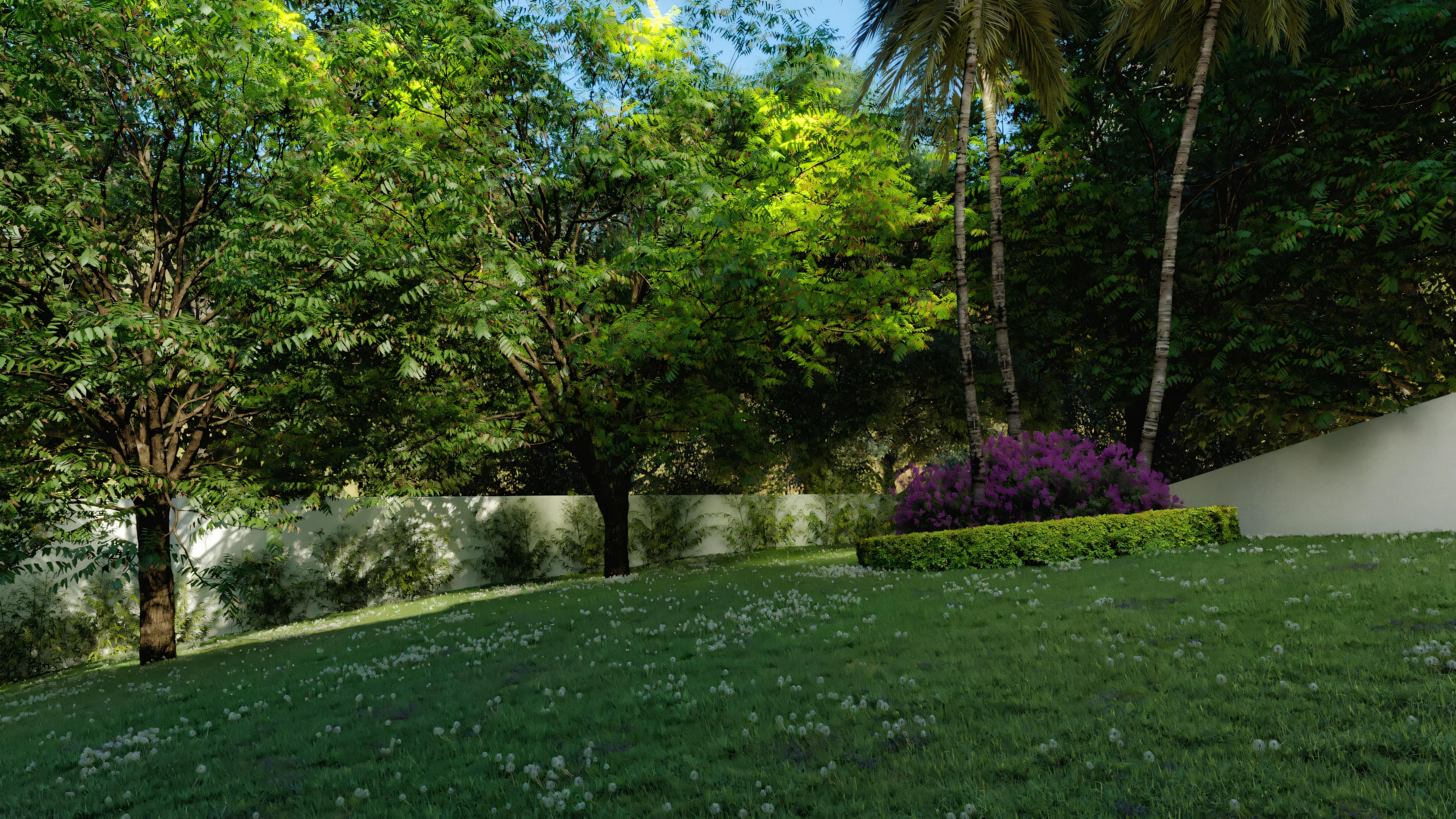 View of the landscaped garden of the country house, showing a sloping lawn with flowers, leafy trees, hedge, flowerbed with purple flowers, and a wall in the background.