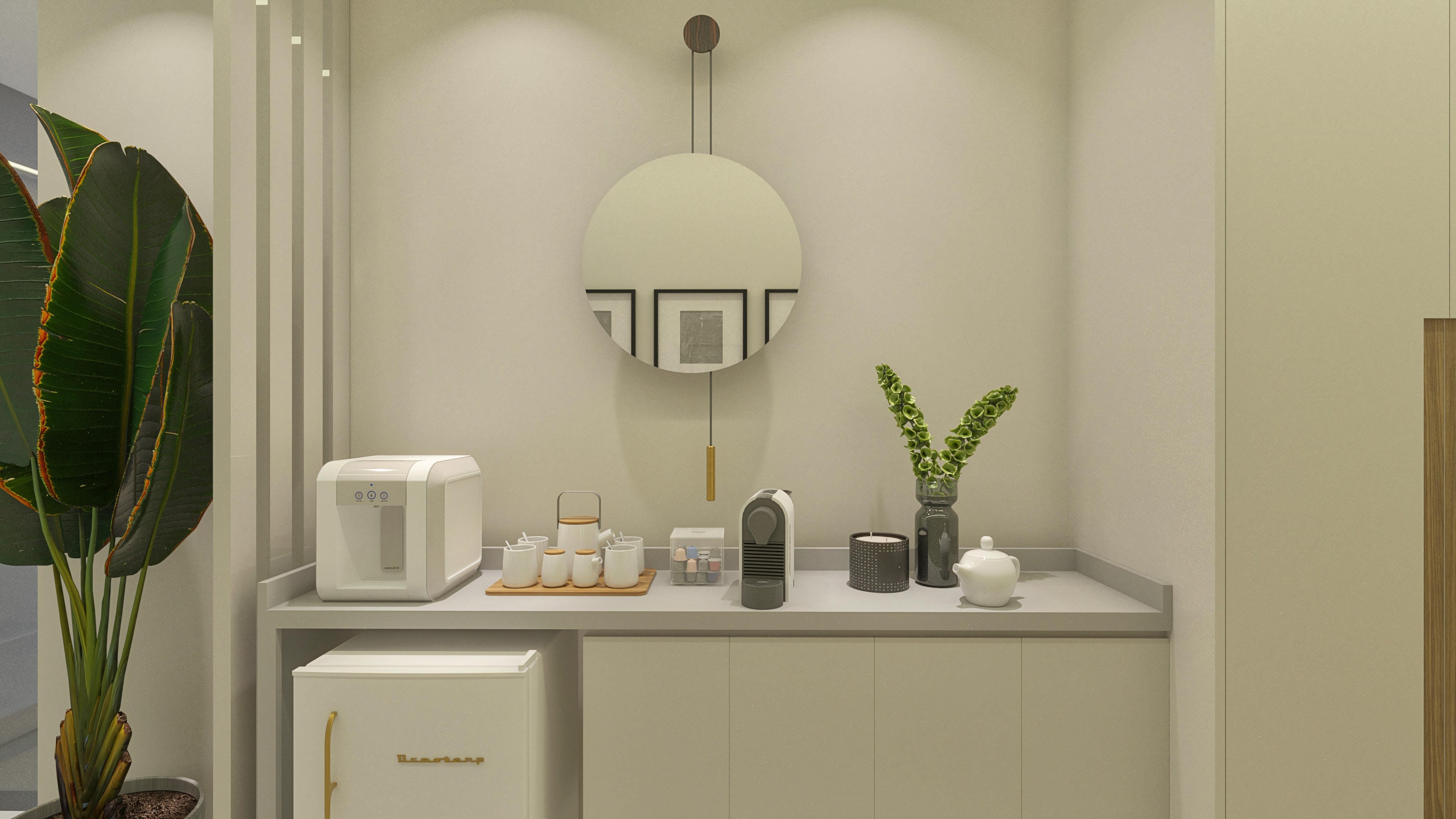 Details of a modern minibar with a coffee maker, kettle, and mini fridge in an elegant setting highlighting decoration with plants. The furniture features a textured finish in neutral tones.