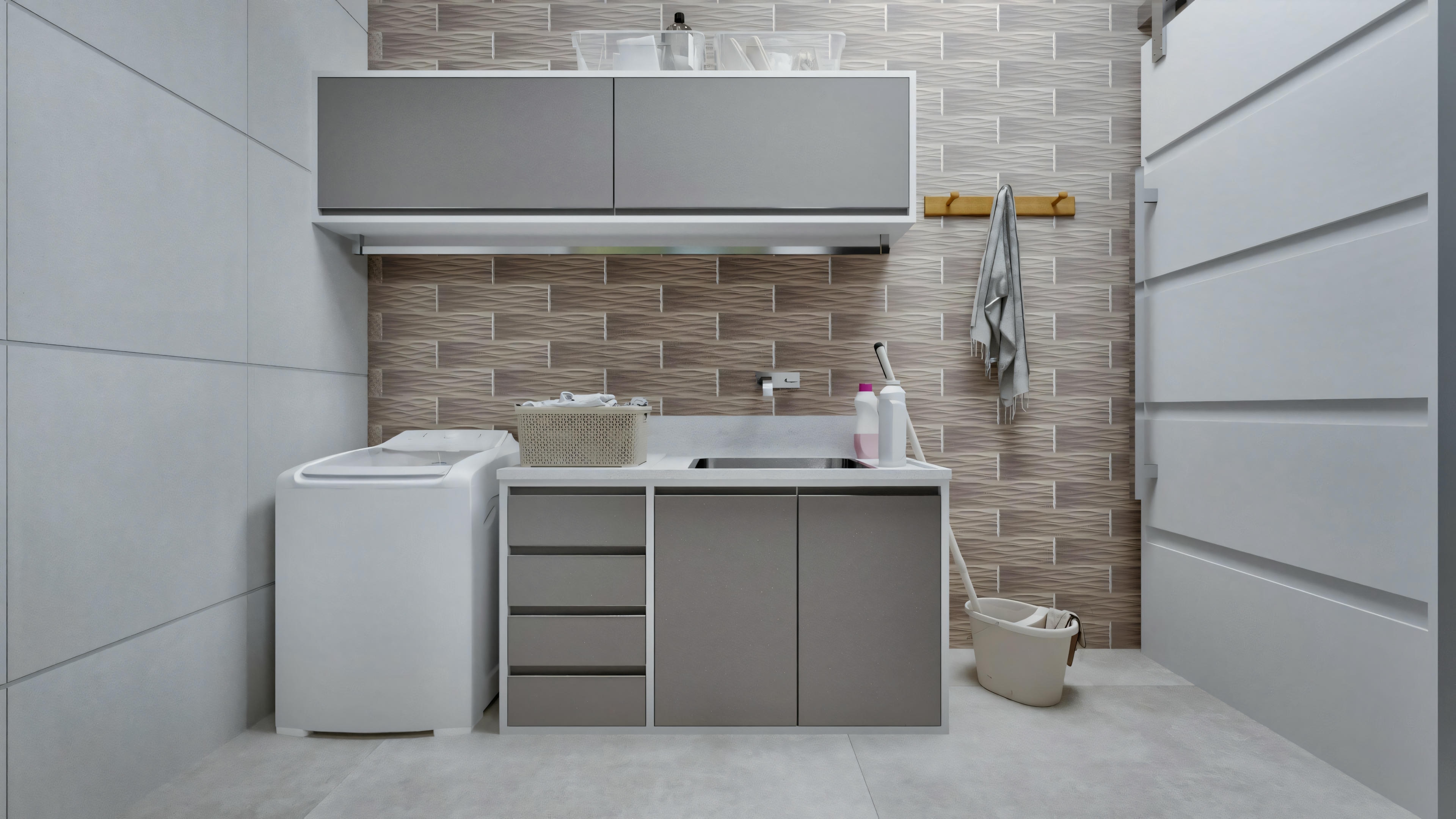 A modern laundry room with a washing machine and sink. There are cabinets above and below the sink area, and to the right, there appears to be a tall storage unit.