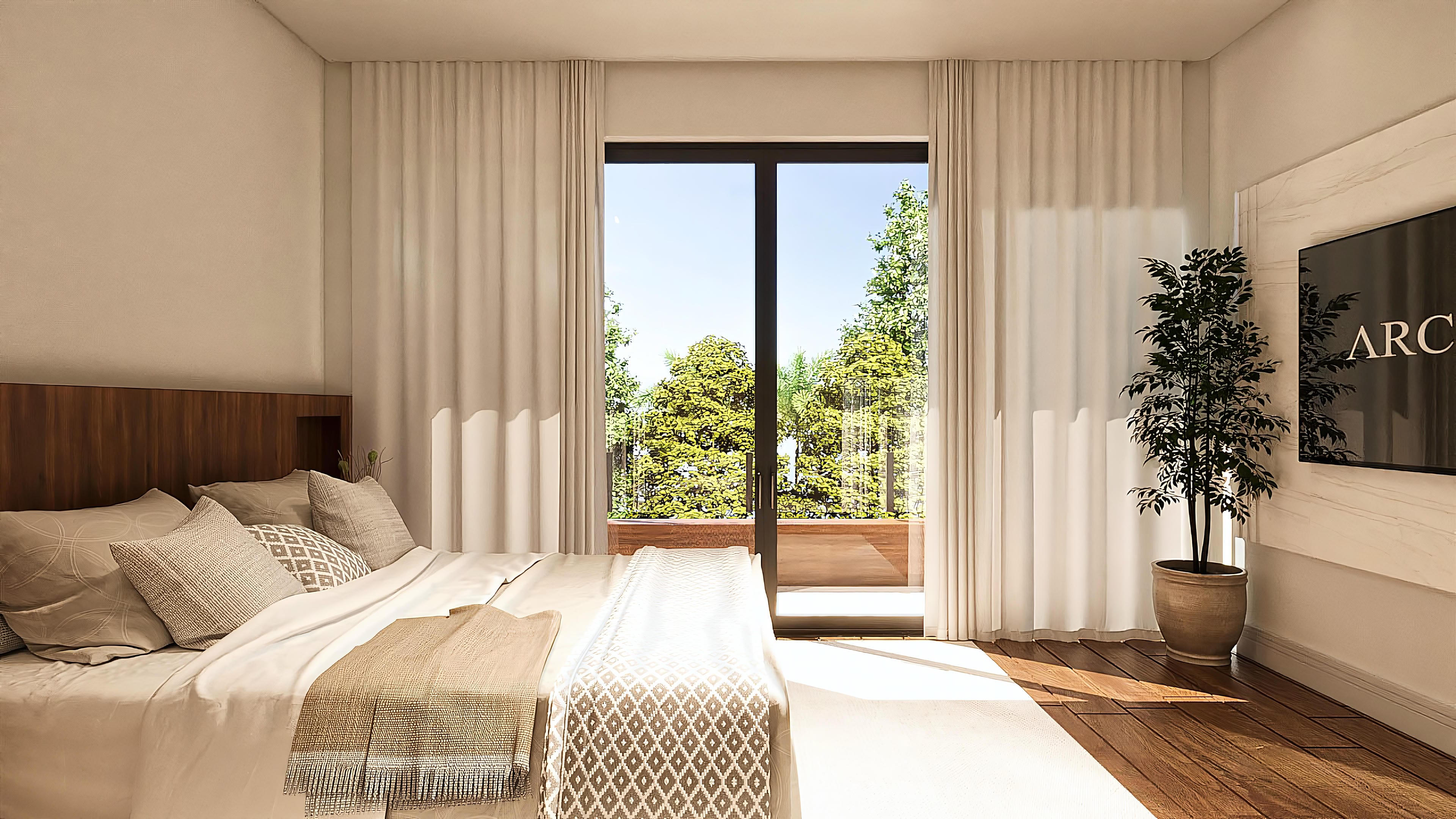 Interior of a bedroom with a comfortable bed, white curtains, and access to a balcony with a view of a green area.