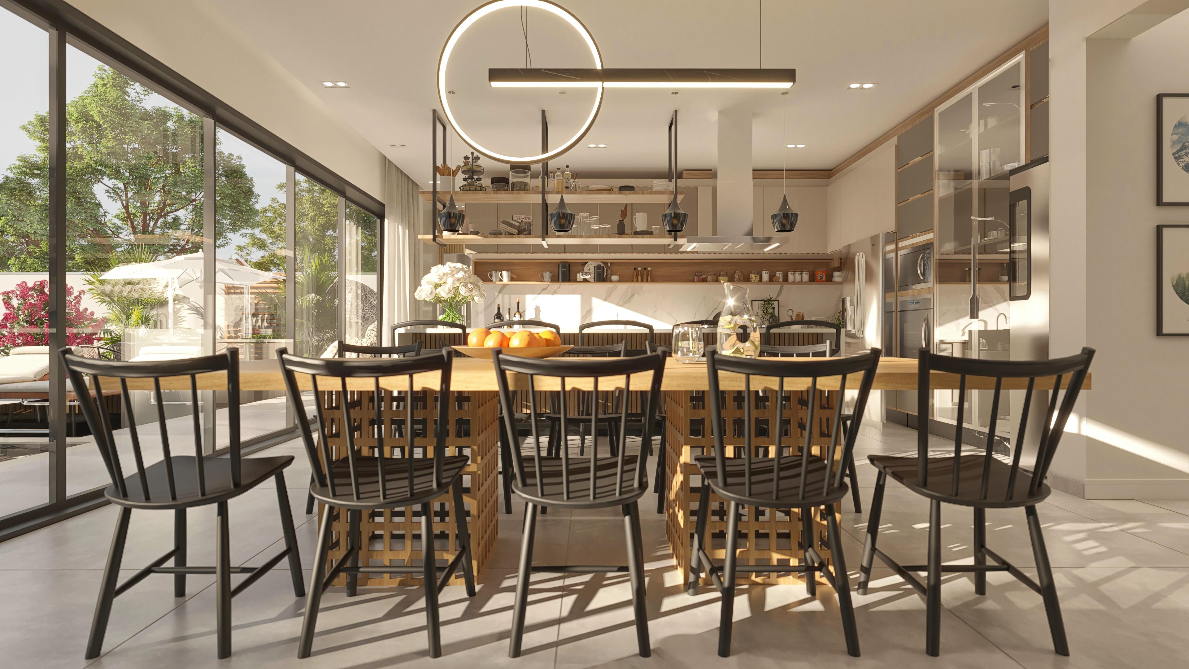 Comedor con mesa de madera y sillas negras, integrado a la cocina moderna con armarios blancos y encimeras de mármol.