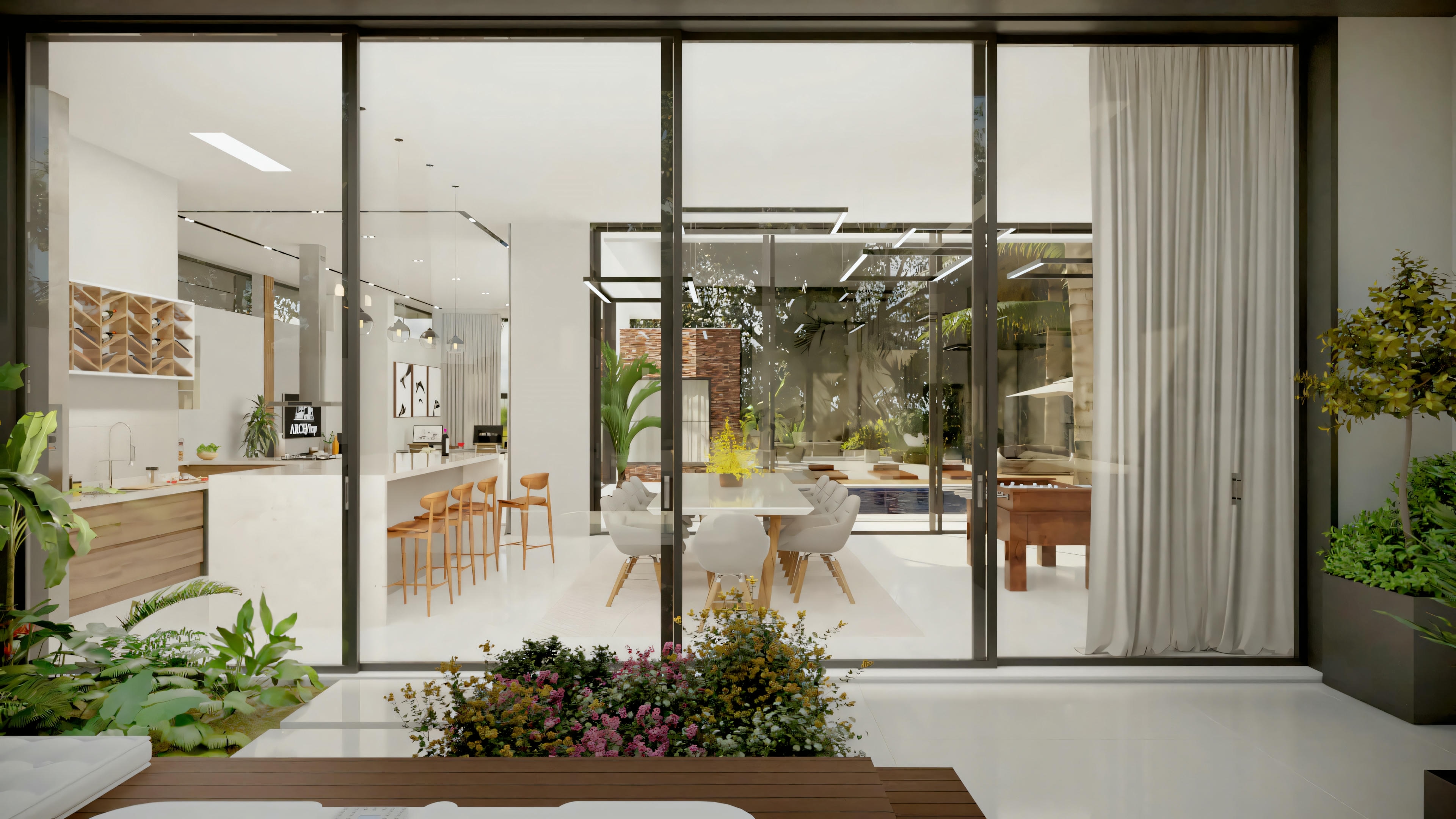 Outdoor area with a patio, chairs, and table, surrounded by glass walls and lush vegetation.