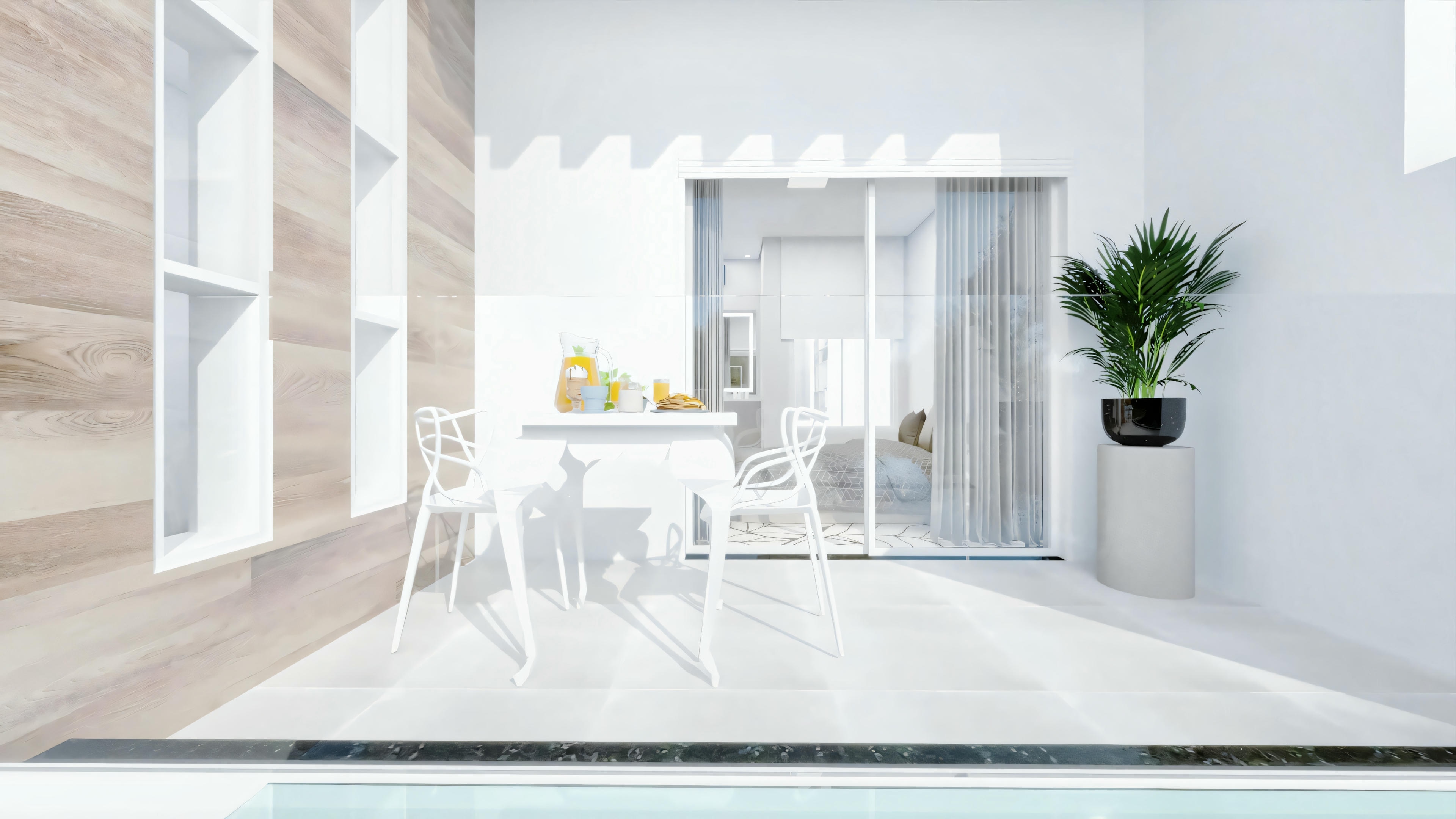 Una habitación minimalista e iluminada con una gran ventana, paredes blancas, piso de madera, una mesa pequeña con dos sillas y una planta en maceta en la esquina.