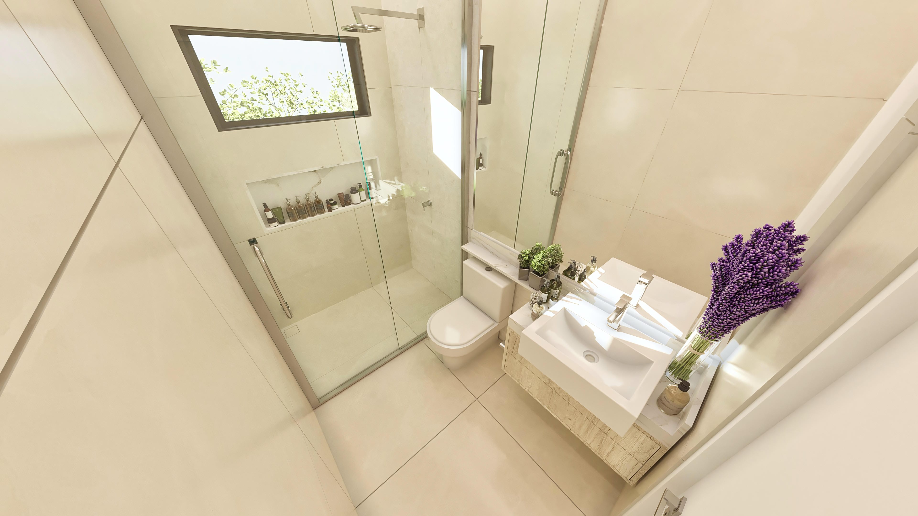 Detalle de baño moderno con revestimiento de porcelanato claro, encimera con lavabo de sobreponer, espejo y nicho con artículos de aseo. Mampara de vidrio transparente y ducha.