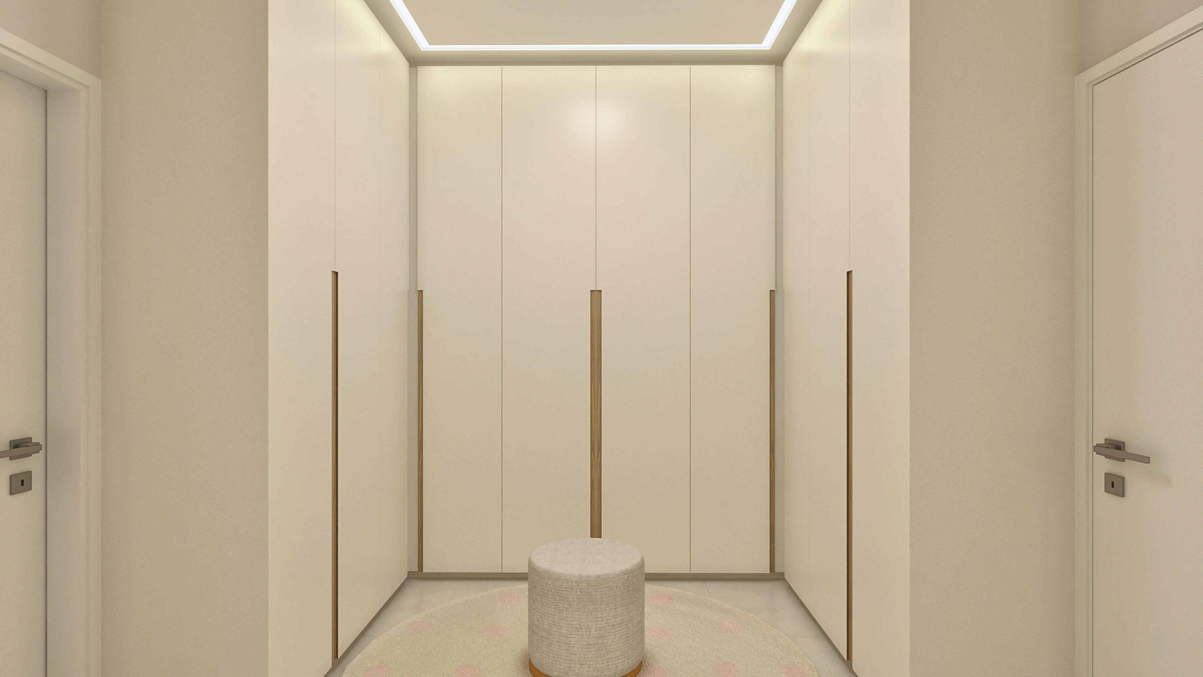 Detalle de un vestidor a medida con puertas en color marfil y tiradores de madera, con iluminación empotrada en el techo y un taburete central.