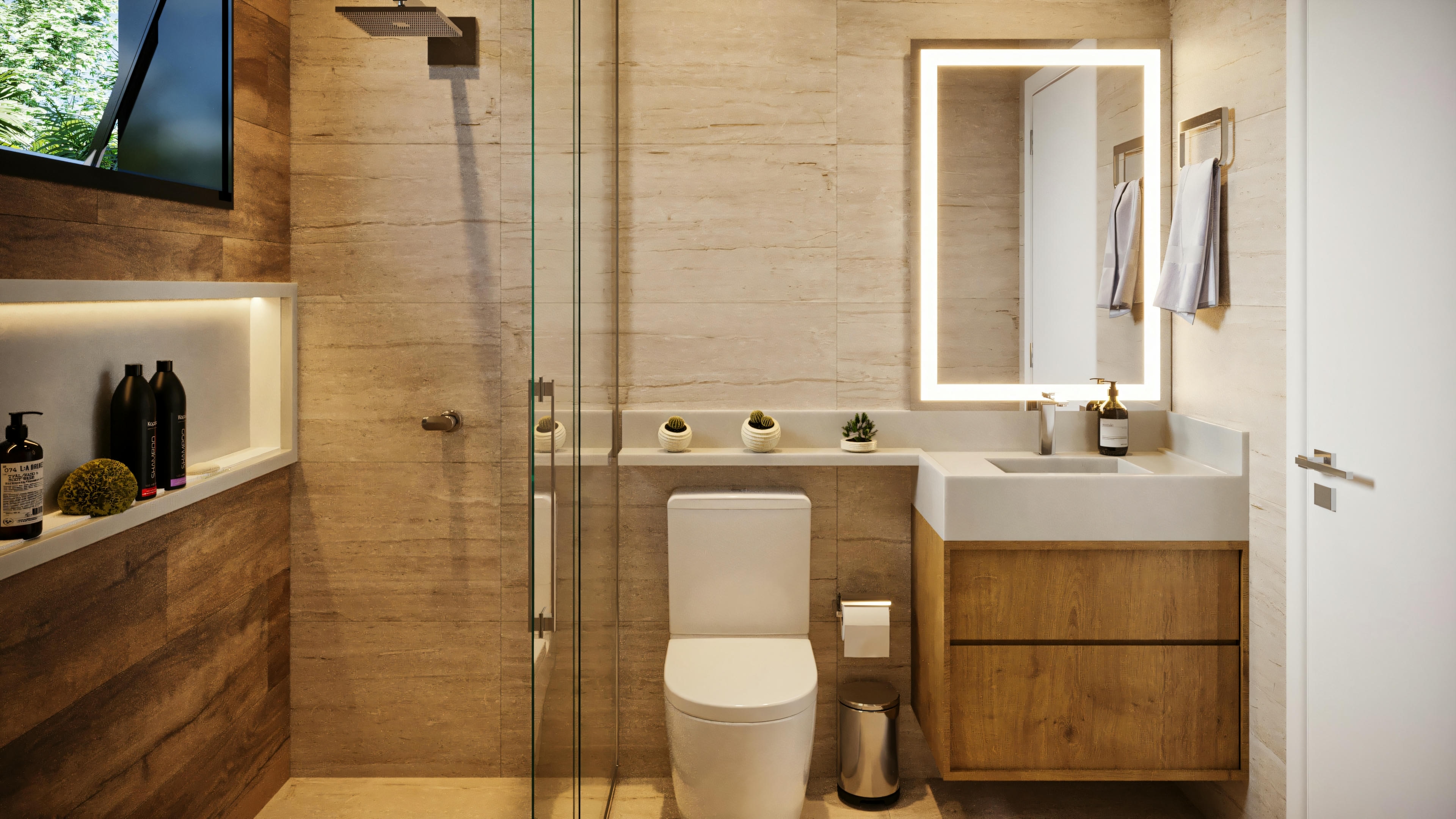 Vista frontal de baño moderno en una de las suites de la casa de planta baja con 3 suites, con box, nicho iluminado, inodoro, encimera con lavabo empotrado y armario de madera, y espejo con iluminación LED.