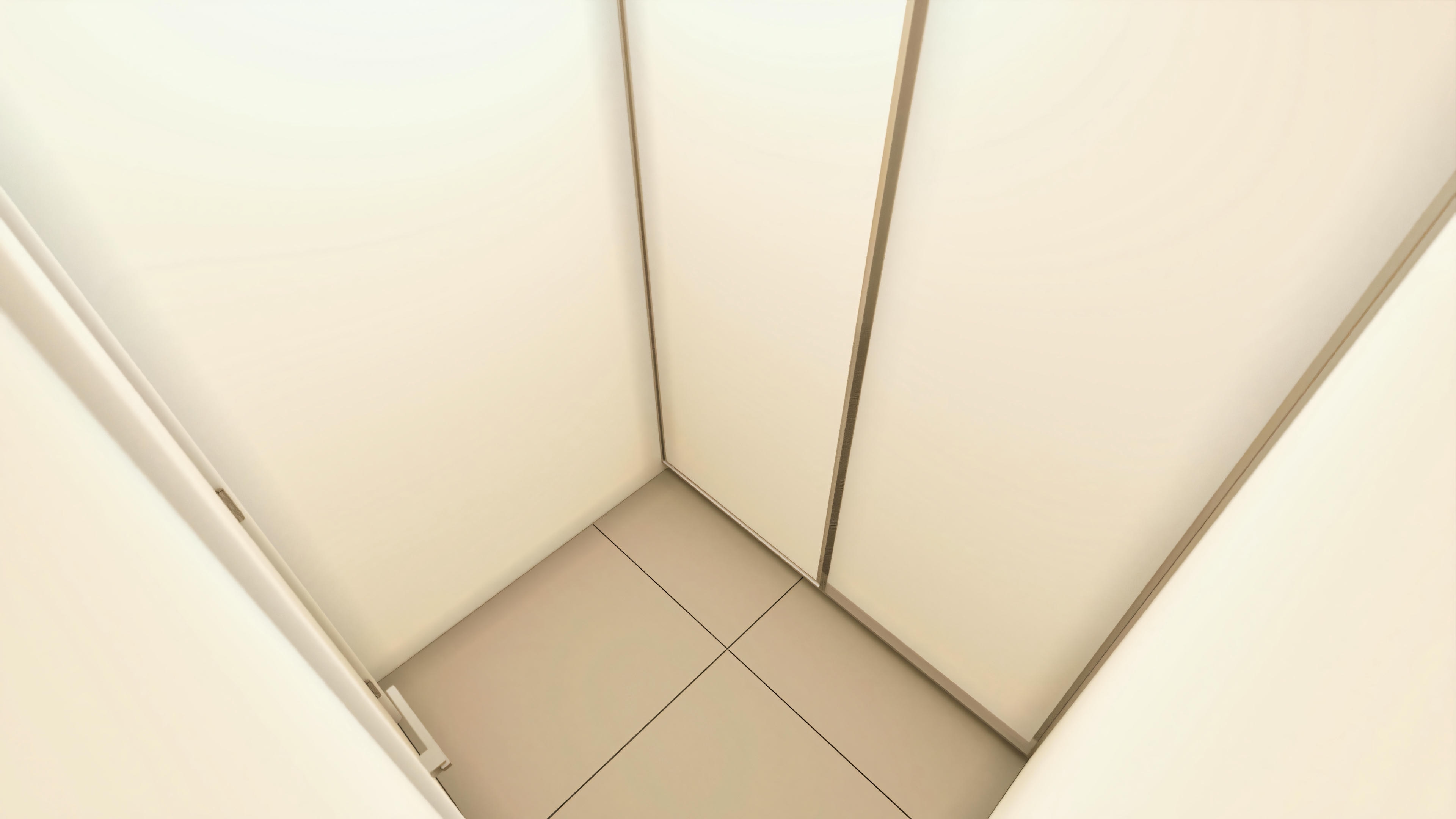 Detalle del interior de un vestidor o armario planeado en suite de casa alto estándar con 5 dormitorios, mostrando la esquina con paneles blancos y piso cerámico claro.