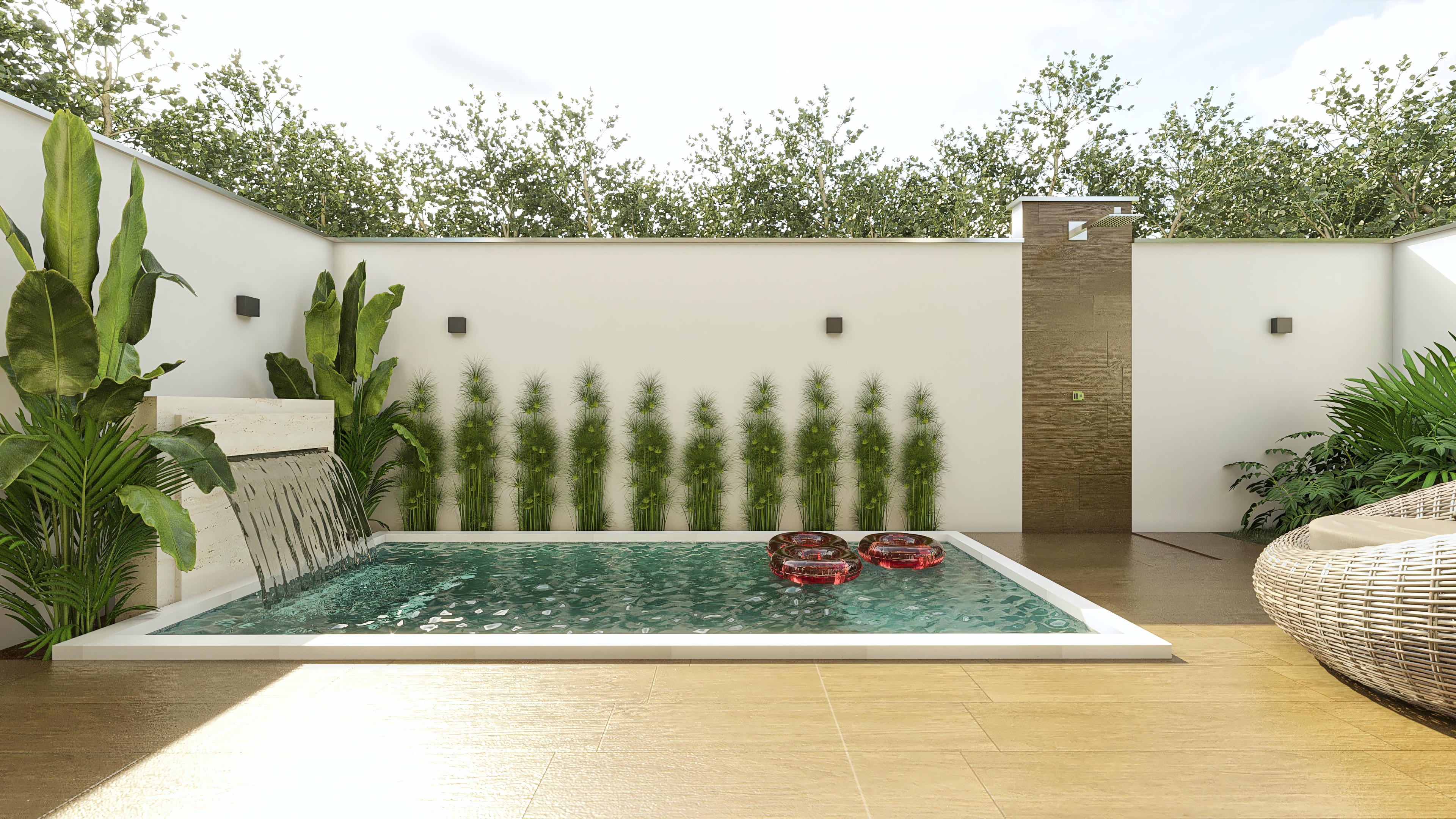 Área de lazer com piscina, cascata, deck em madeira e um chuveiro externo com revestimento amadeirado. Plantas tropicais complementam o paisagismo.