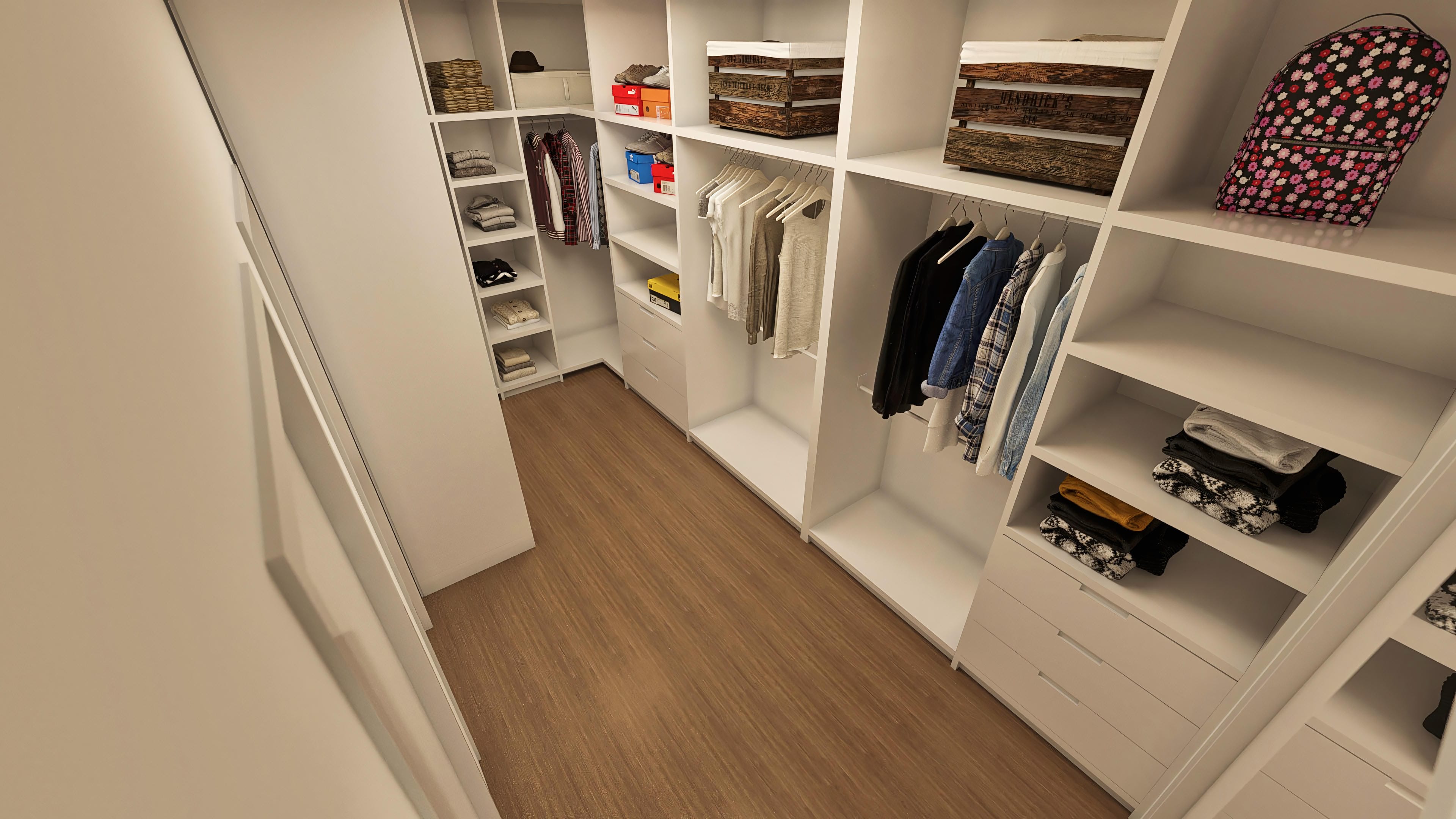 Interior de un vestidor planificado con estantes blancos, cajones, percheros para ropa y piso amaderado, destacando la organización y el diseño moderno.